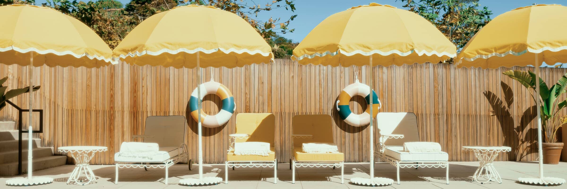 yellow patio umbrellas poolside with sun loungers