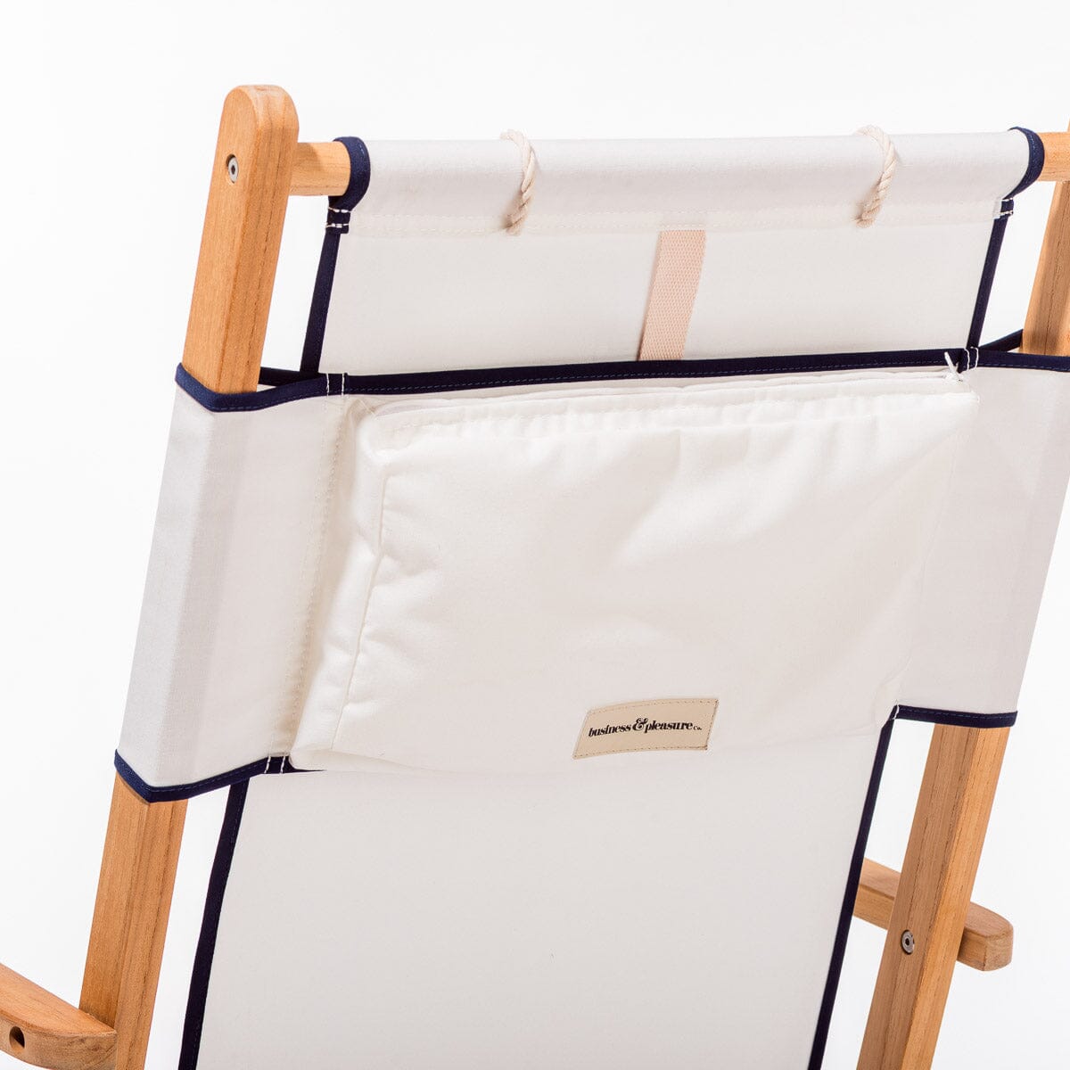 Wooden deck chair with white canvas seat and backrest with navy blue piping