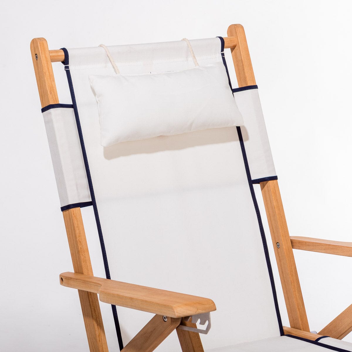 Wooden deck chair with white canvas seat and backrest with navy blue piping