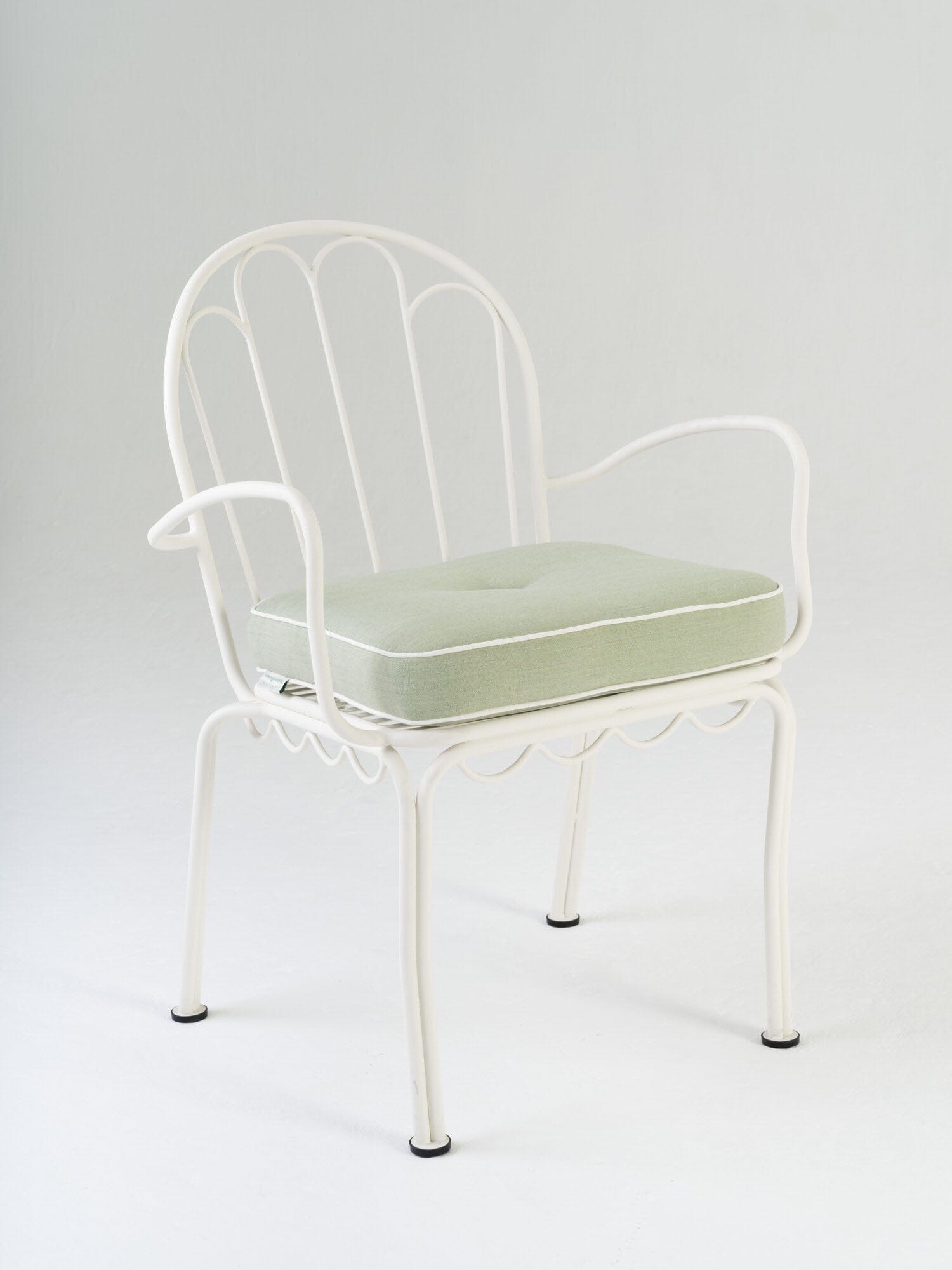 green chair cushion and white metal chair angled in studio
