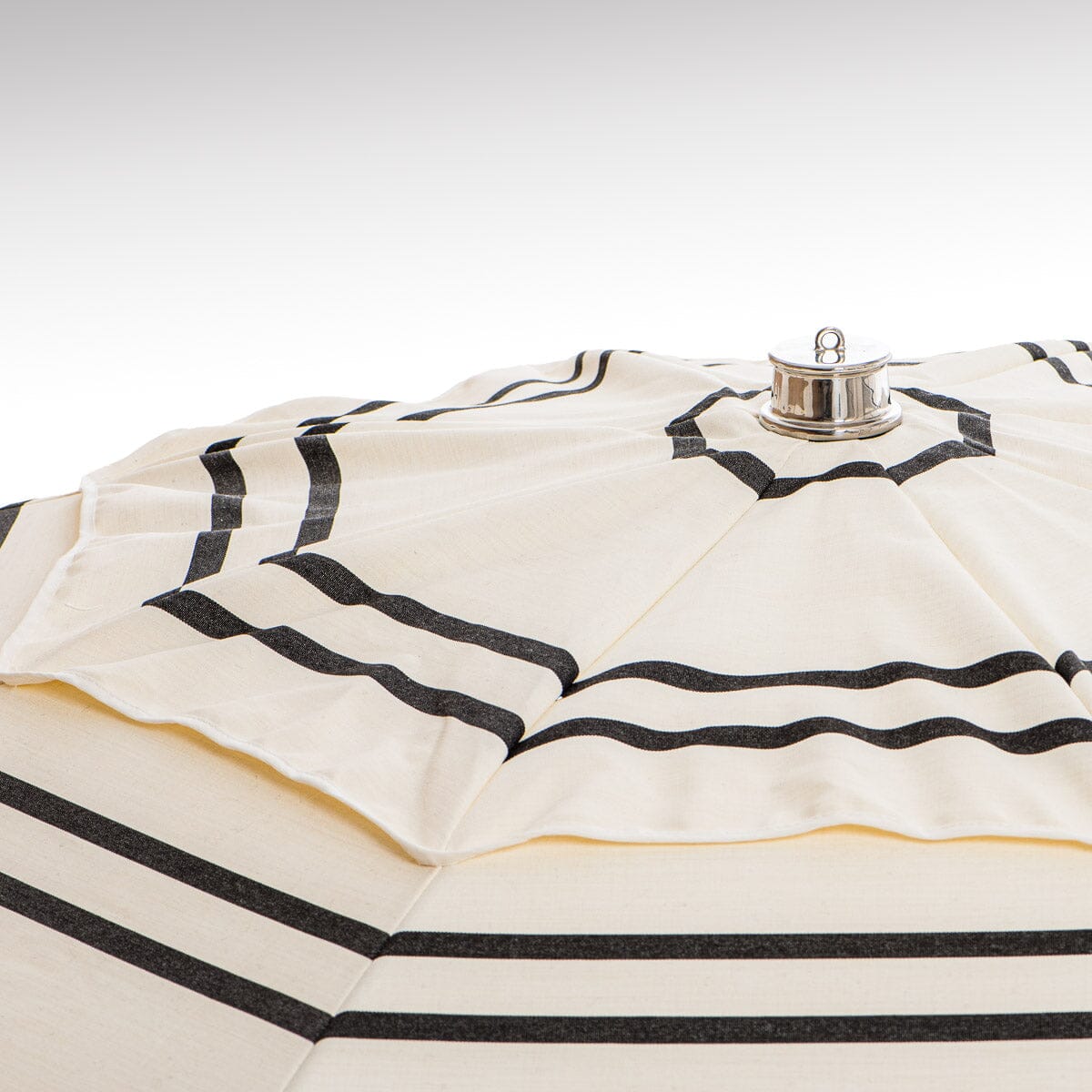 chrome top cap detail on black and white stripe patio umbrella