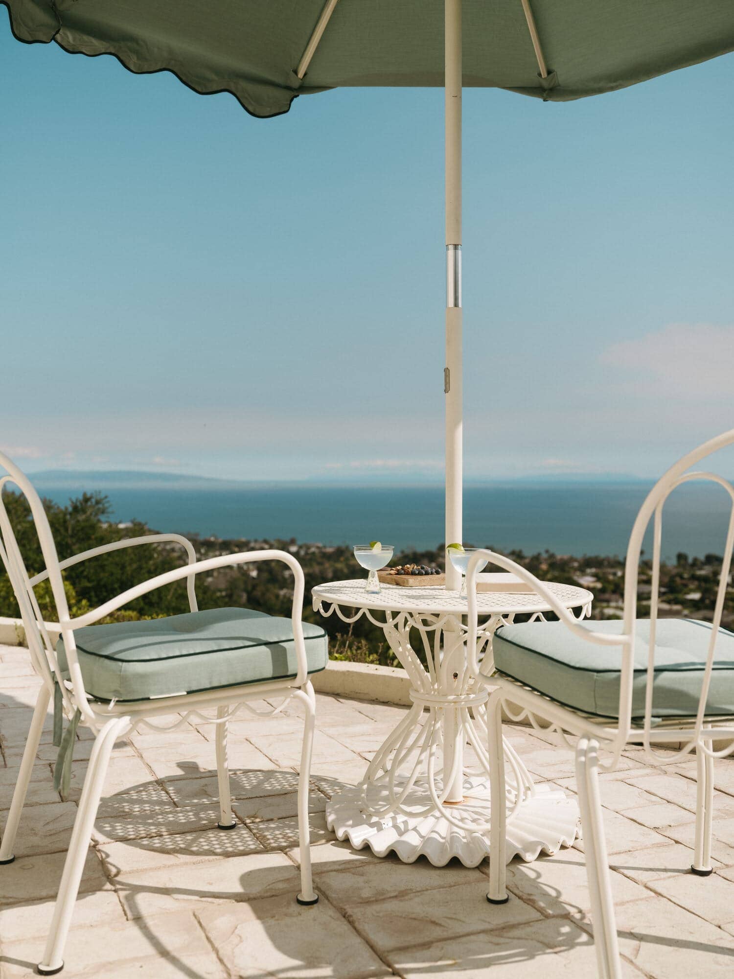 Riviera green umbrella and chairs on a patio