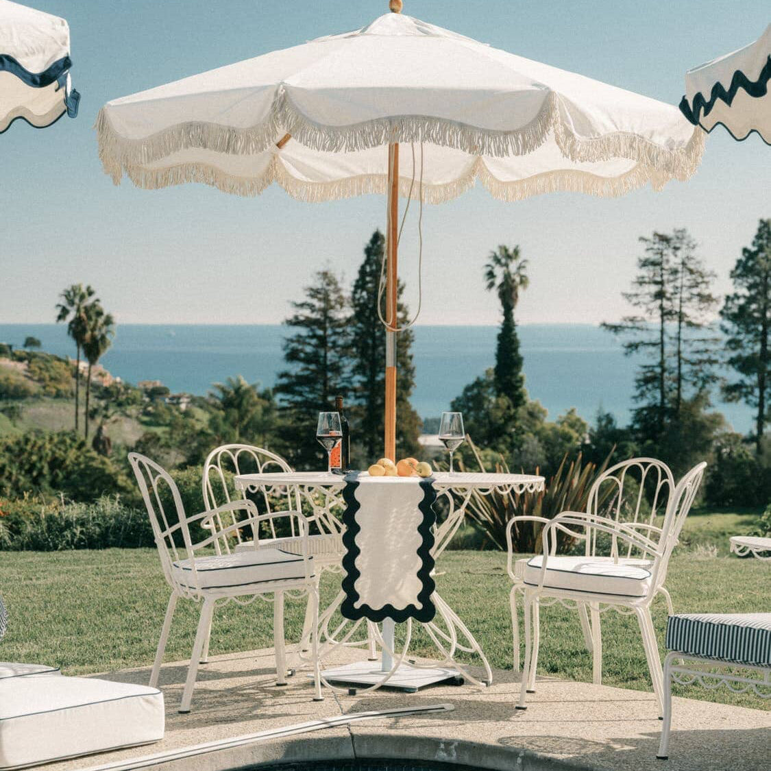 Outdoor dining table with chairs next to a pool
