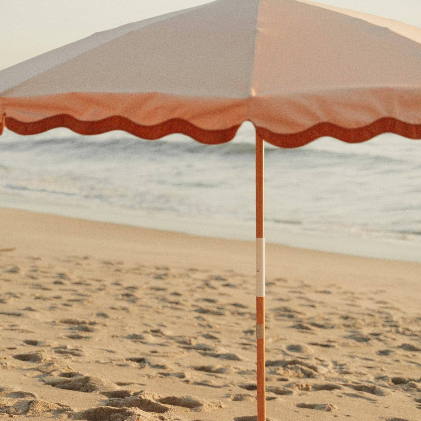 Riviera pink beach set up with umbrella, towel and cooler