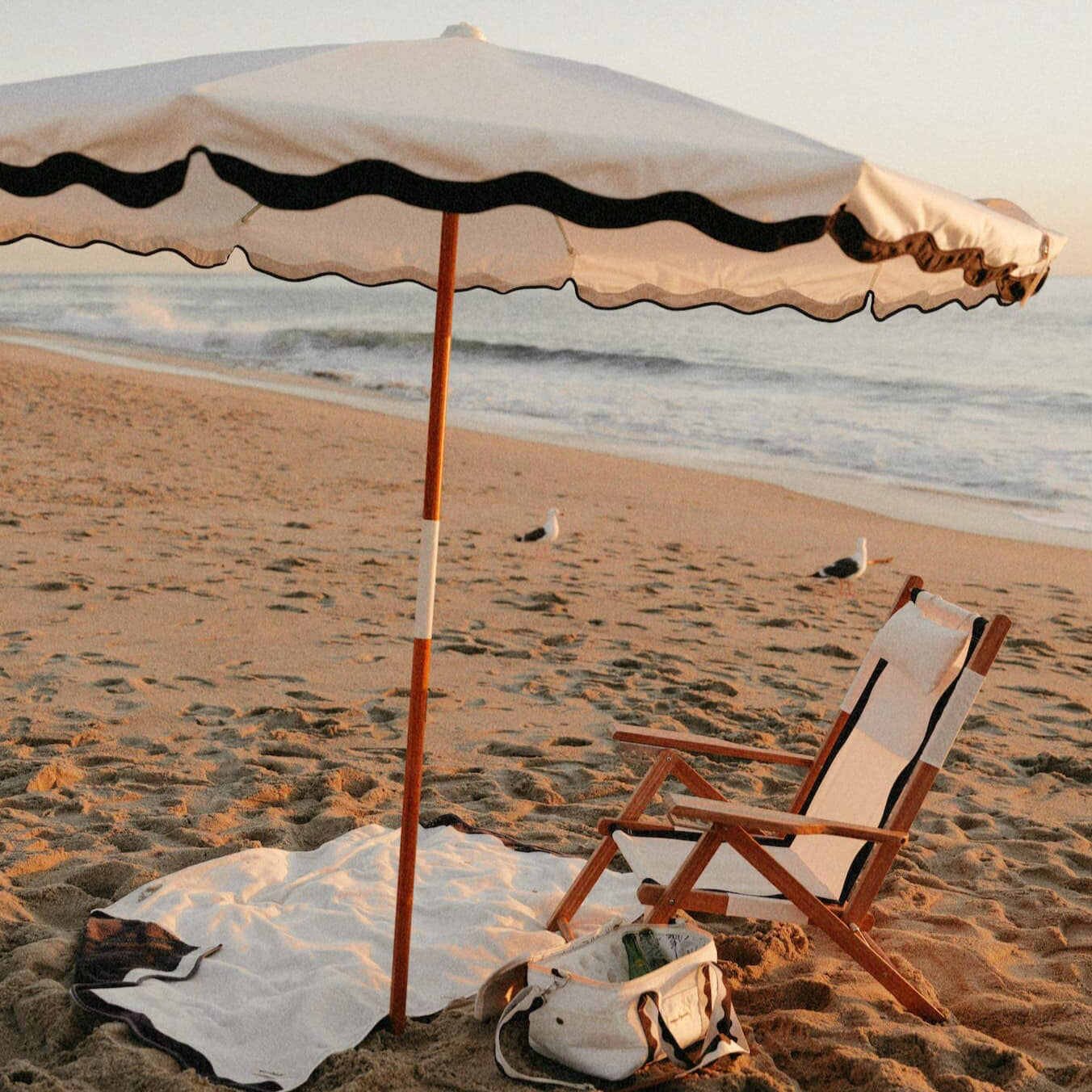 Riviera white beach set up with umbrella, chair, towel and cooler