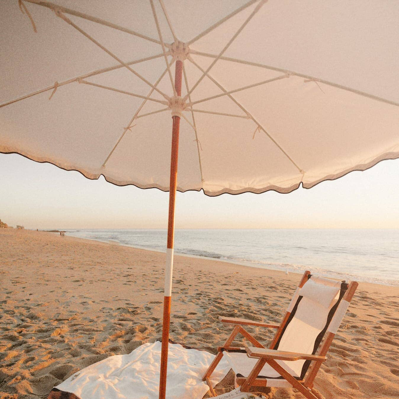 Riviera white beach set up with umbrella, chair, towel and cooler
