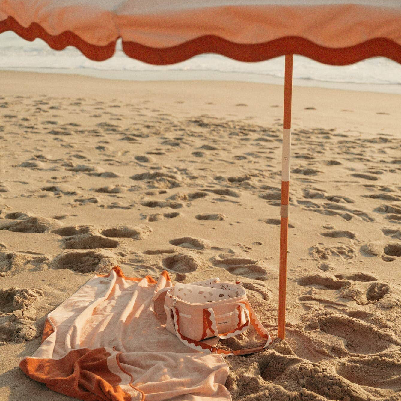 Riviera pink beach set up with umbrella, towel and cooler