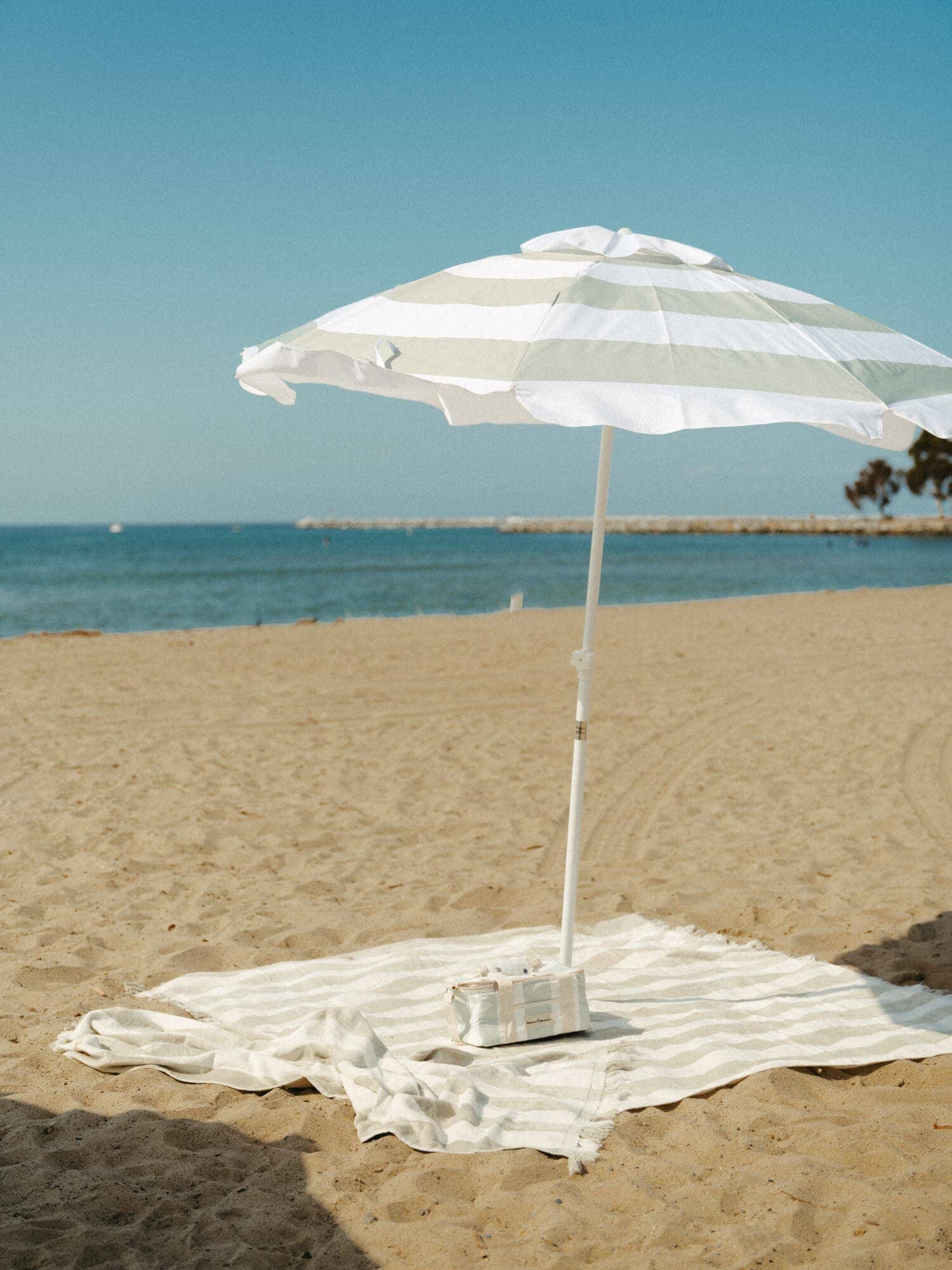 Sage holiday cooler, umbrella and towel on the beach