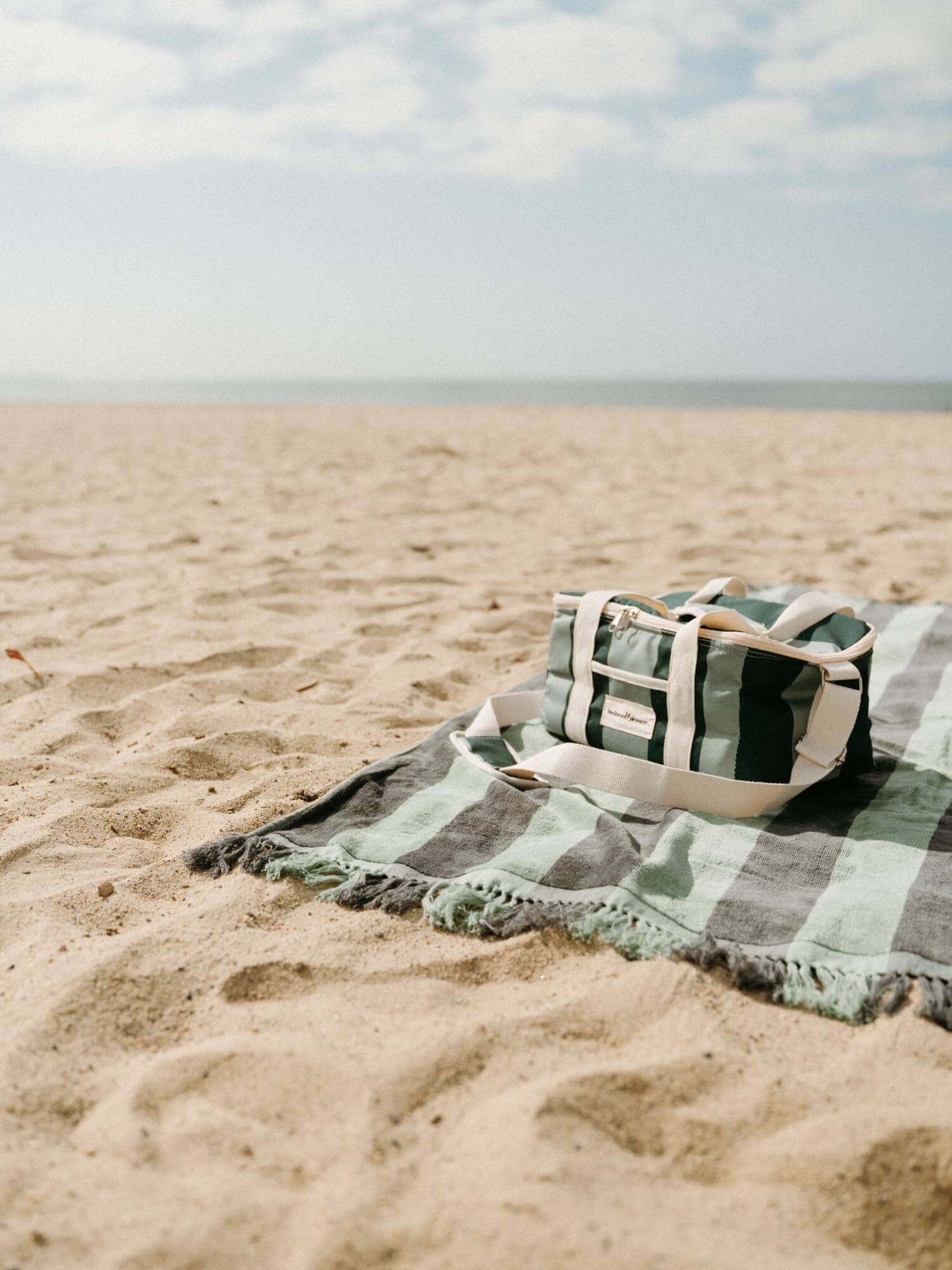 70s panel green towel and cooler on the sand