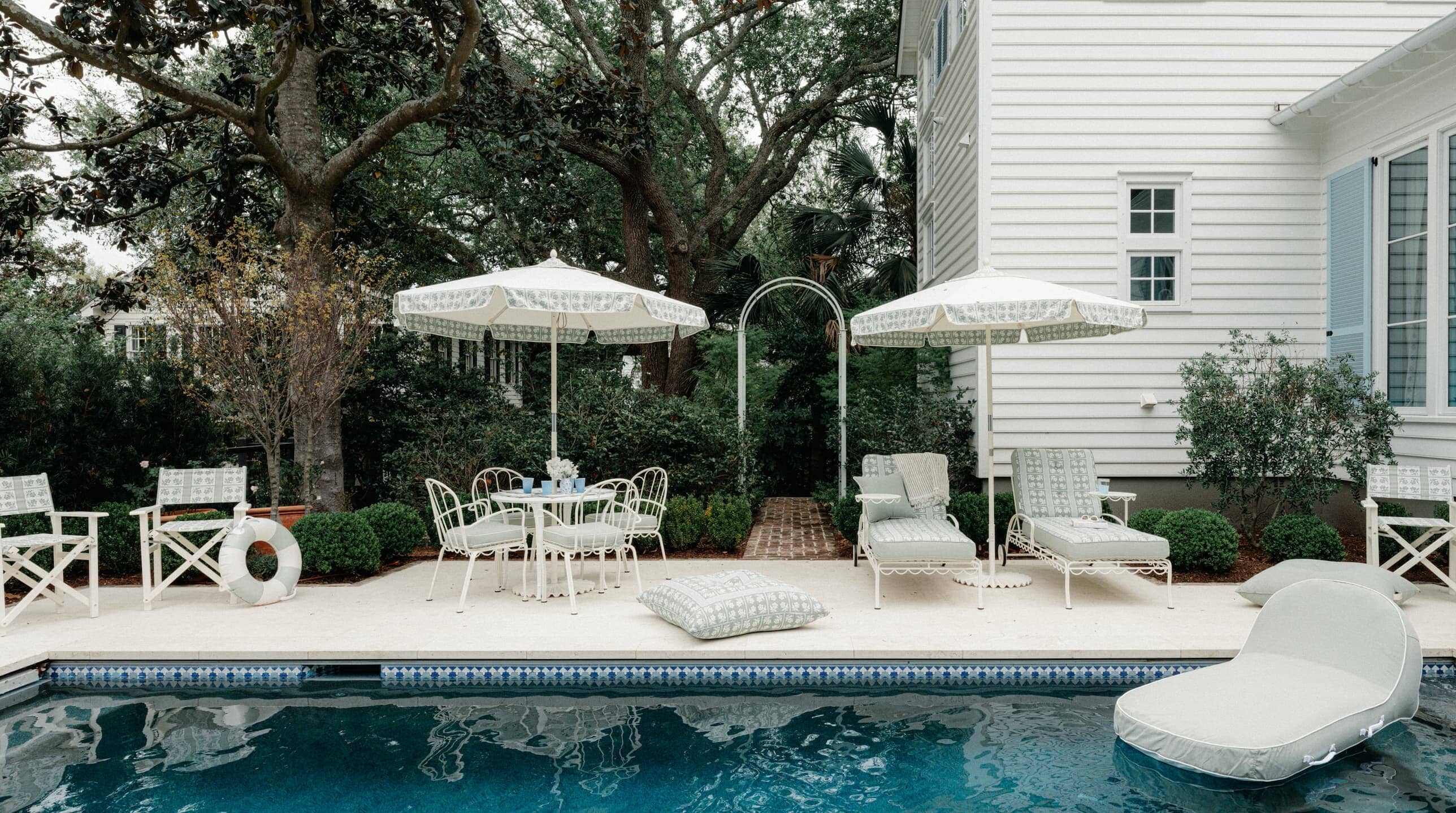 Outdoor pool area with umbrellas, chairs and outdoor cushions