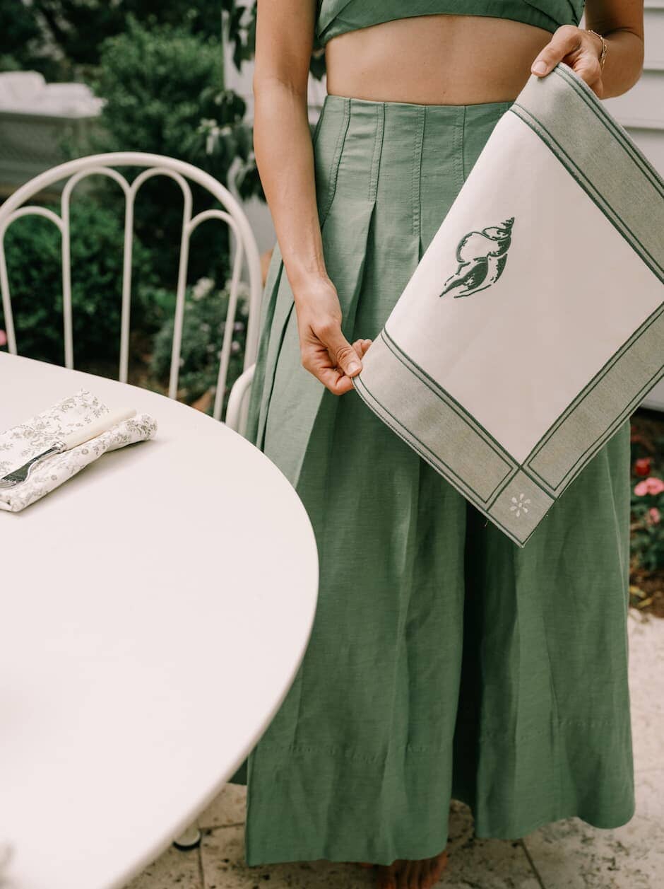 Woman holding julia berolzheimer placemat next to a table