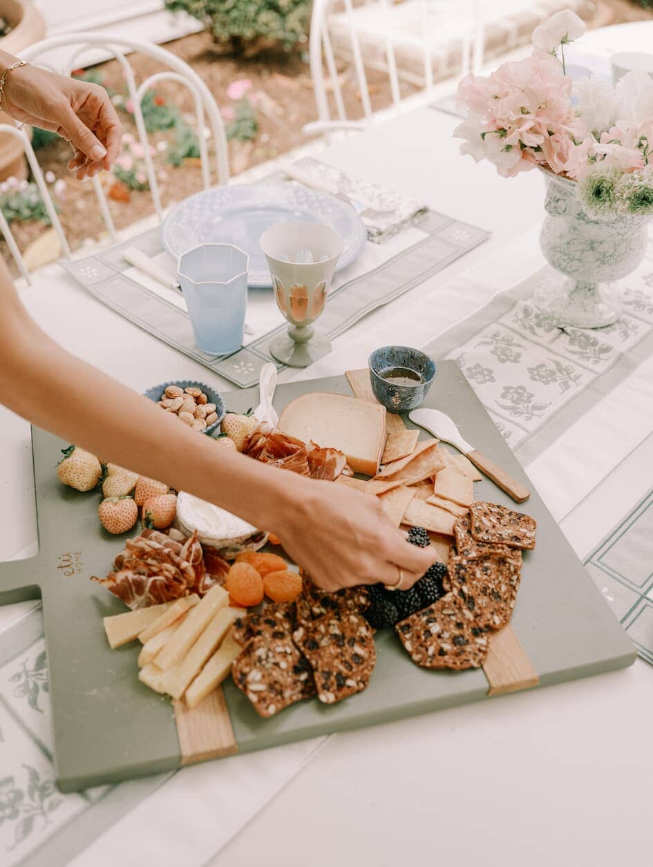 Cheese board on a table with julia berolzheimer placemats and table runner