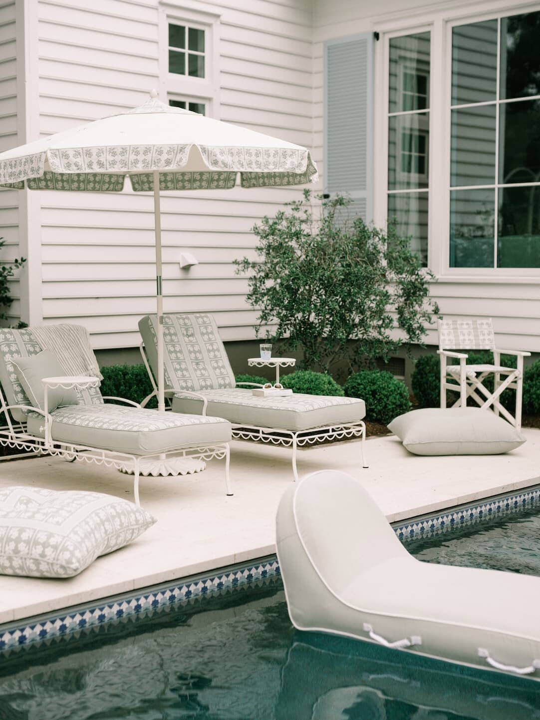 Outdoor pool area with lounge chairs and pool loungers