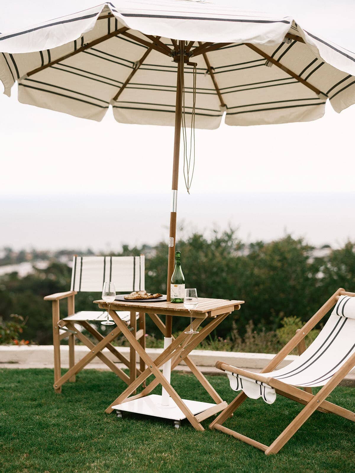 Malibu black stripe umbrella and chairs on grass