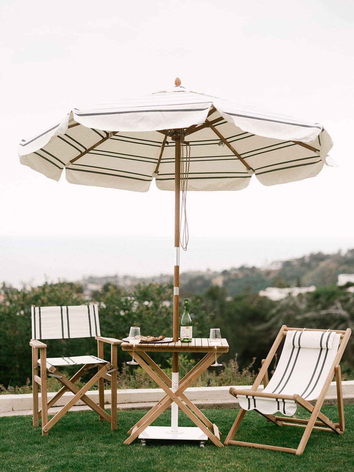 Malibu black stripe umbrella and chairs on grass