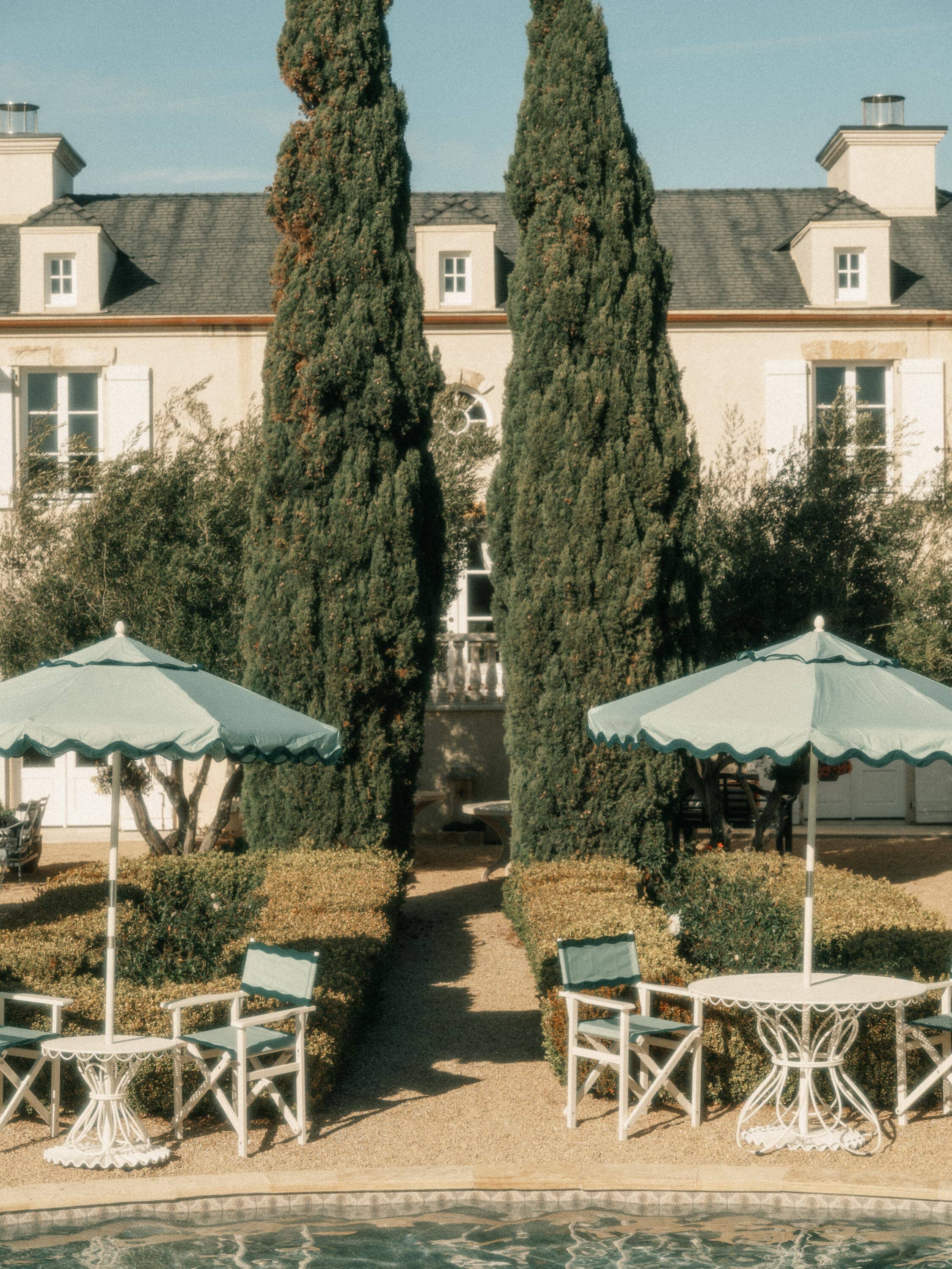 Riviera green market umbrellas next to a pool