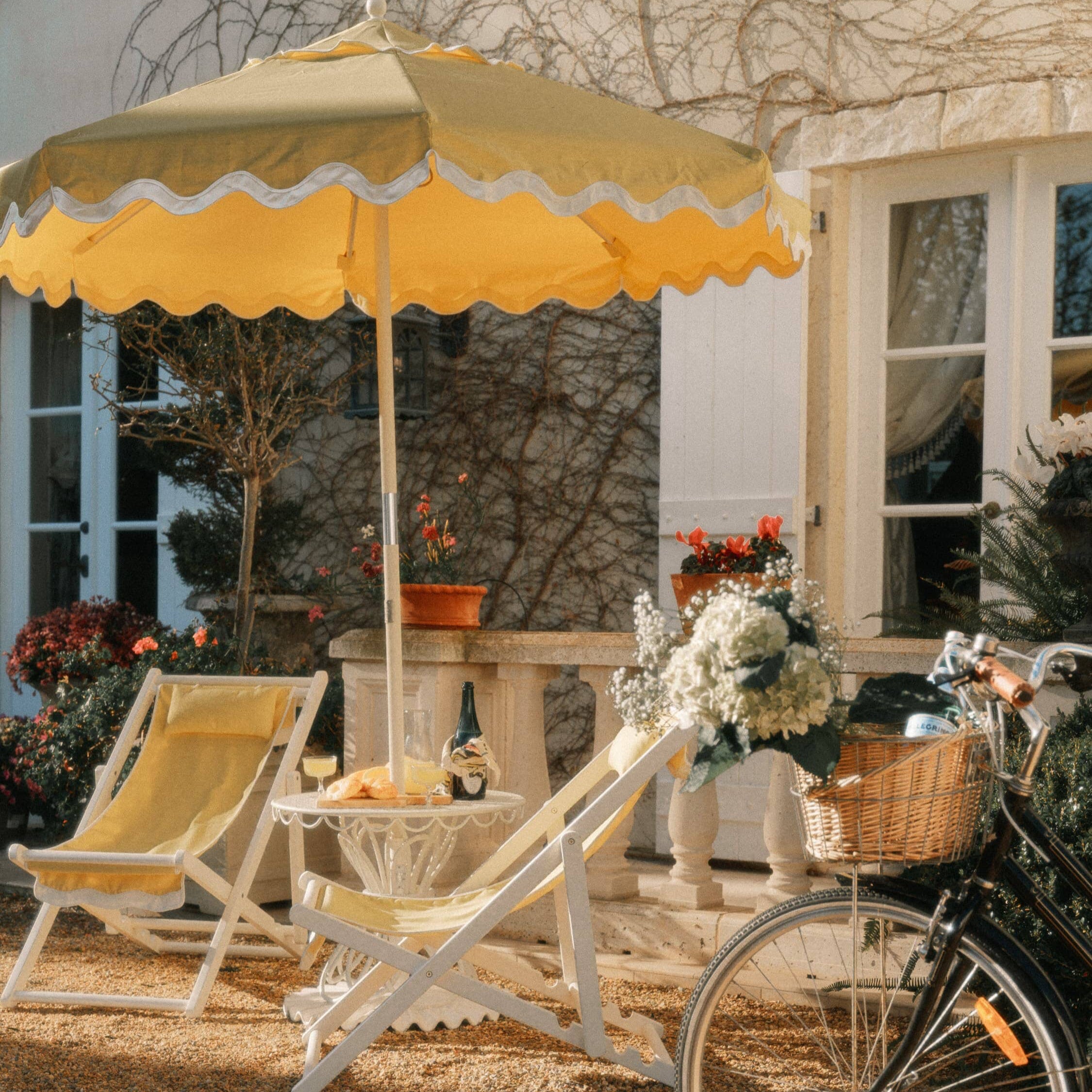 Riviera mimosa market umbrella with matching chairs on a garden patio
