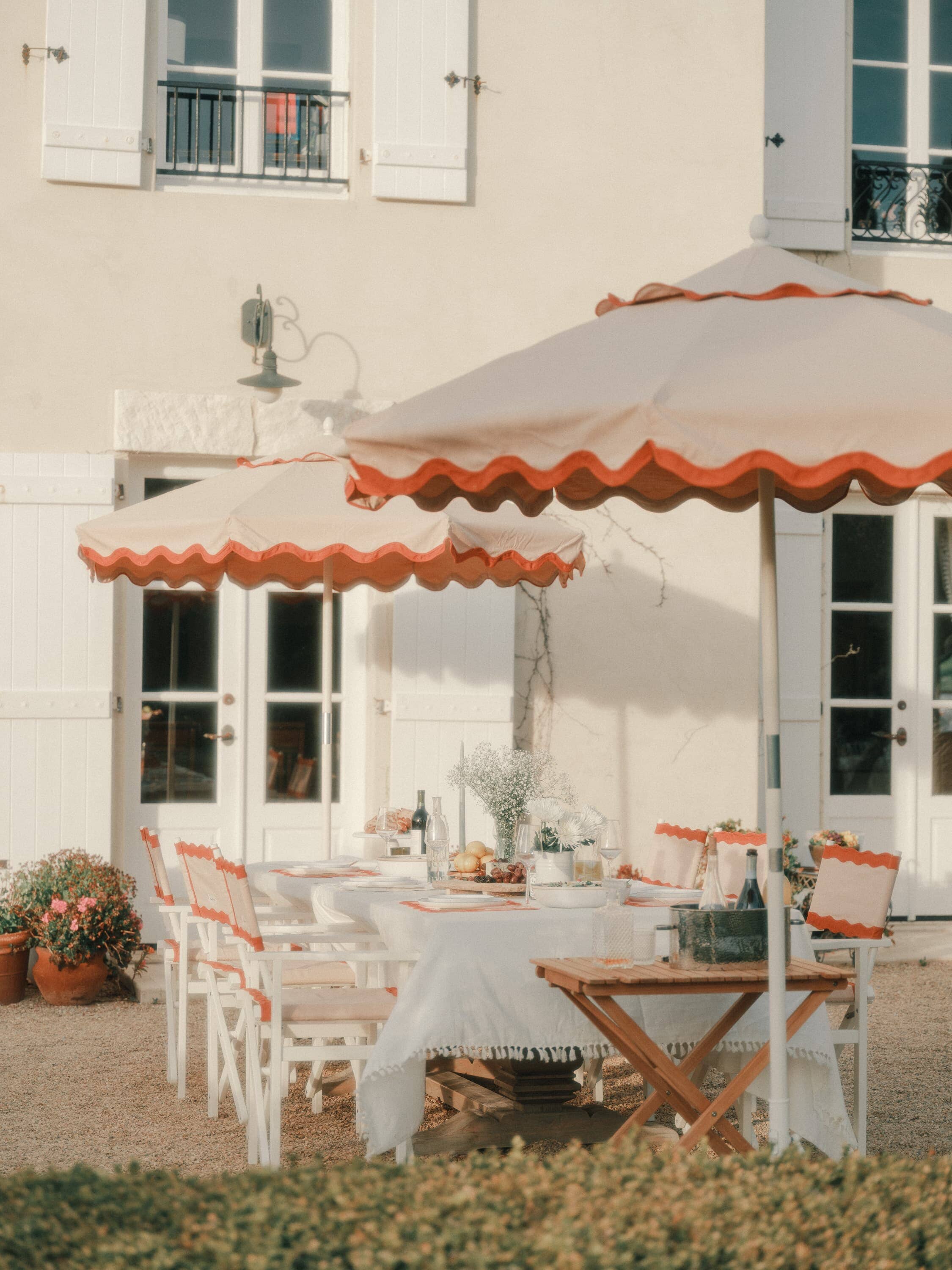 Riviera pink market umbrella and pink directors chairs on a patio