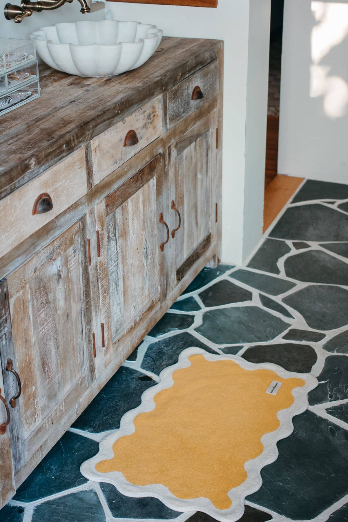 Mimosa bath mat on a stone bathroom floor