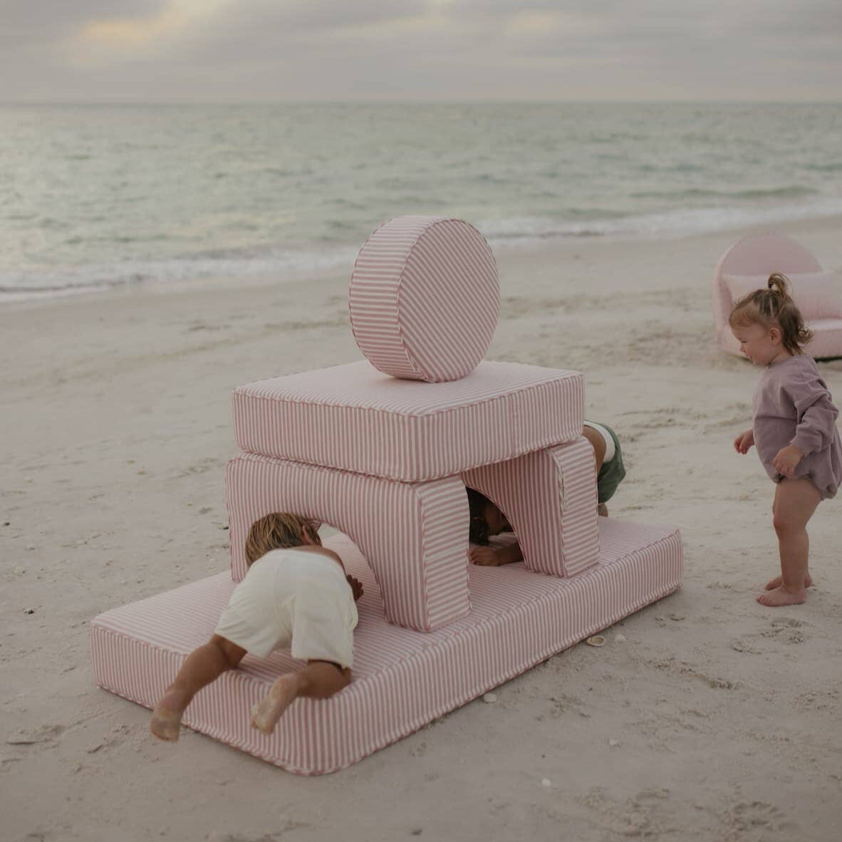 kids playing on modular pillow stack on the beach