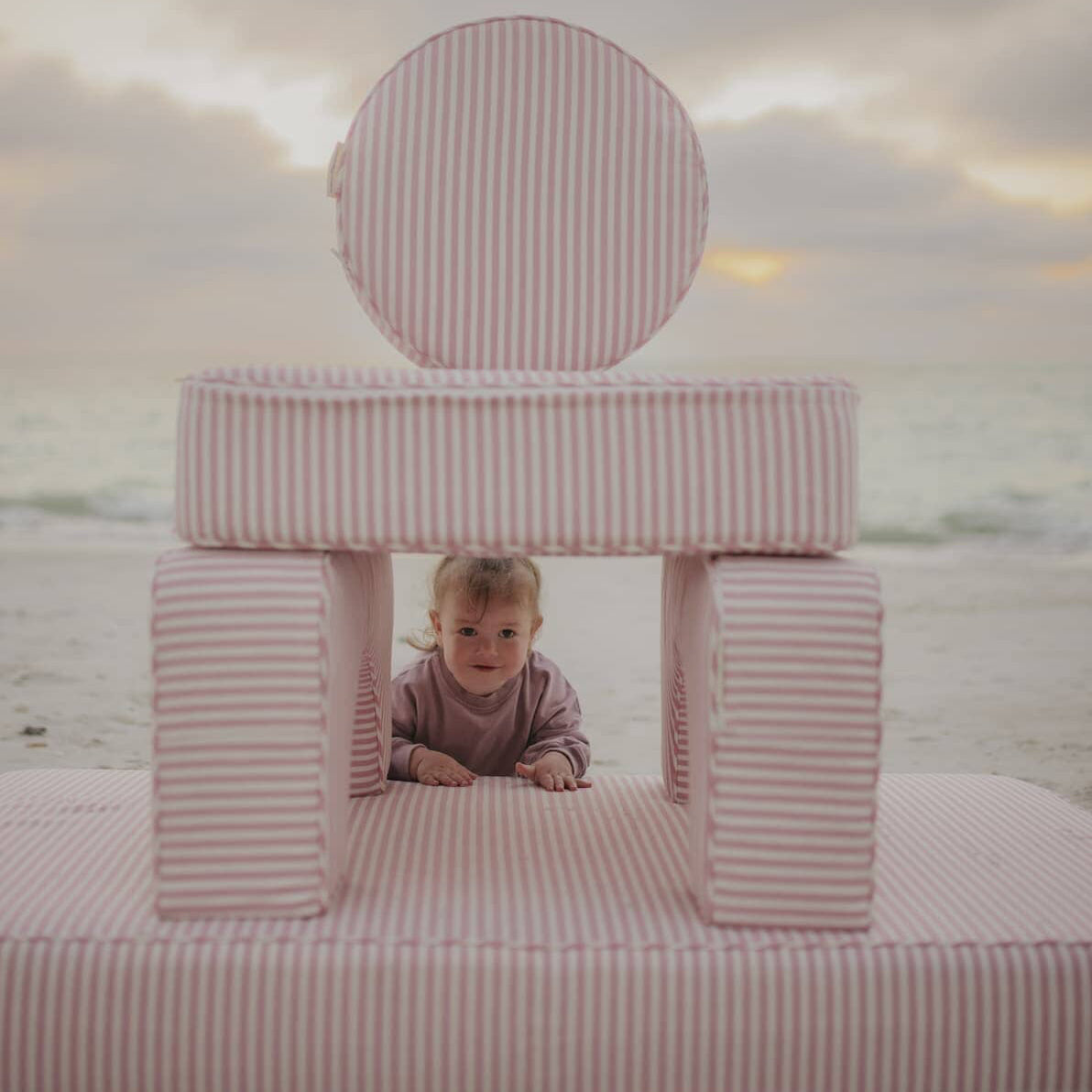 kids playing on modular pillow stack on the beach
