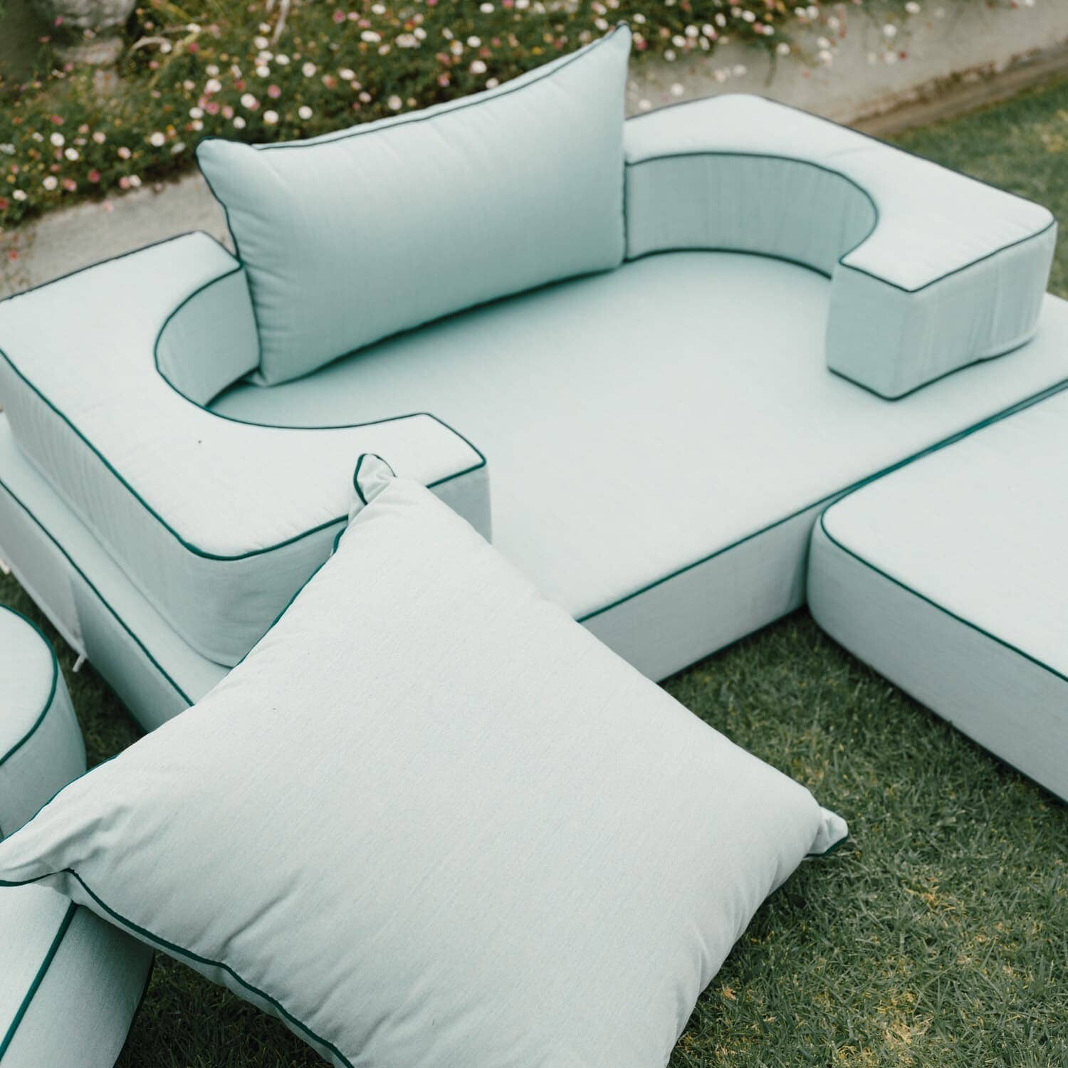 Riviera green modular pillow stack in a garden setting