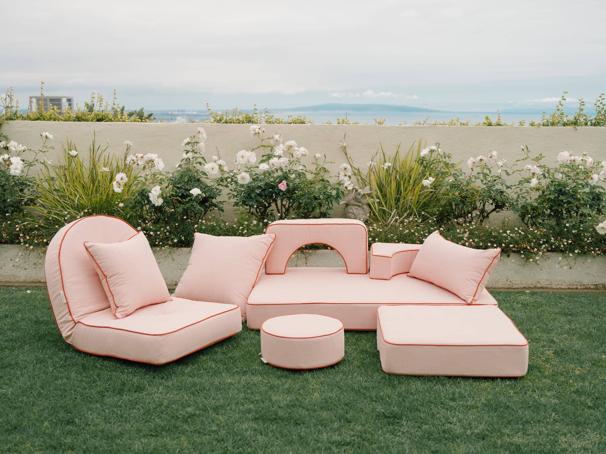 Riviera pink modular pillow stack in a garden setting