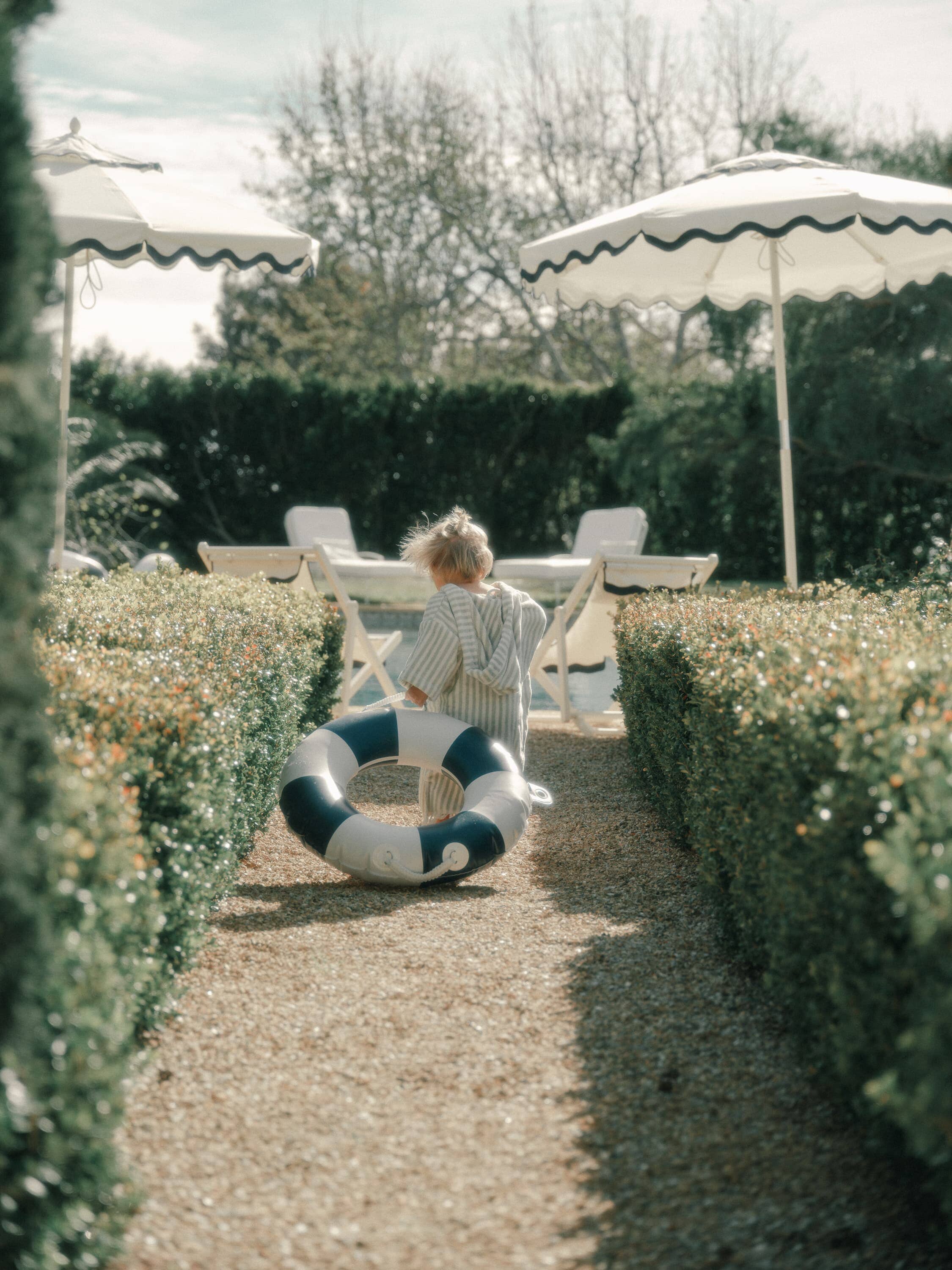 child holding navy pool ring