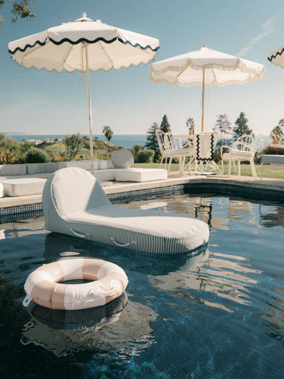 pink pool ring and pool lounger in a pool