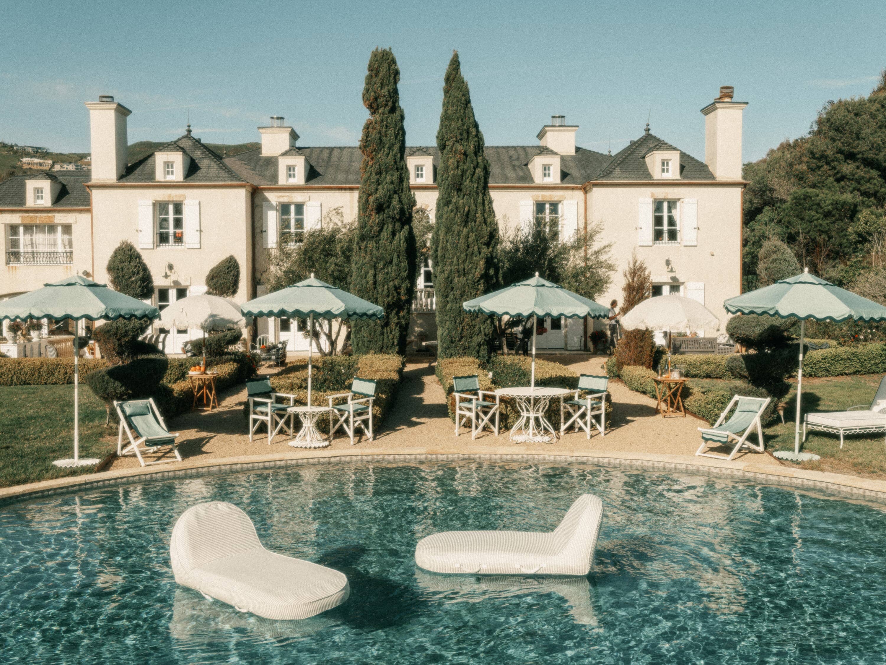 sage pool loungers in a pool