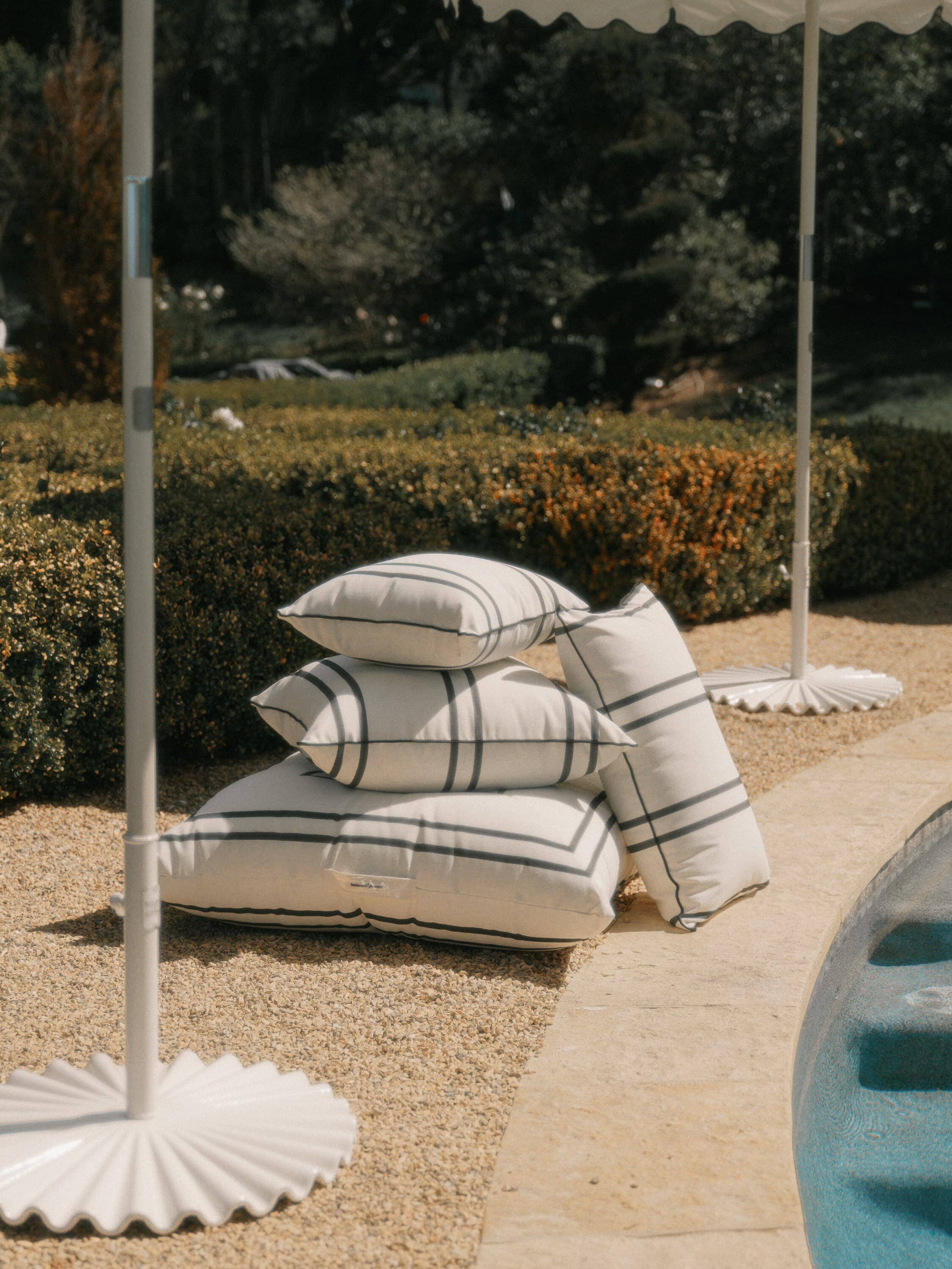 stack of malibu black stripe pillows on a patio