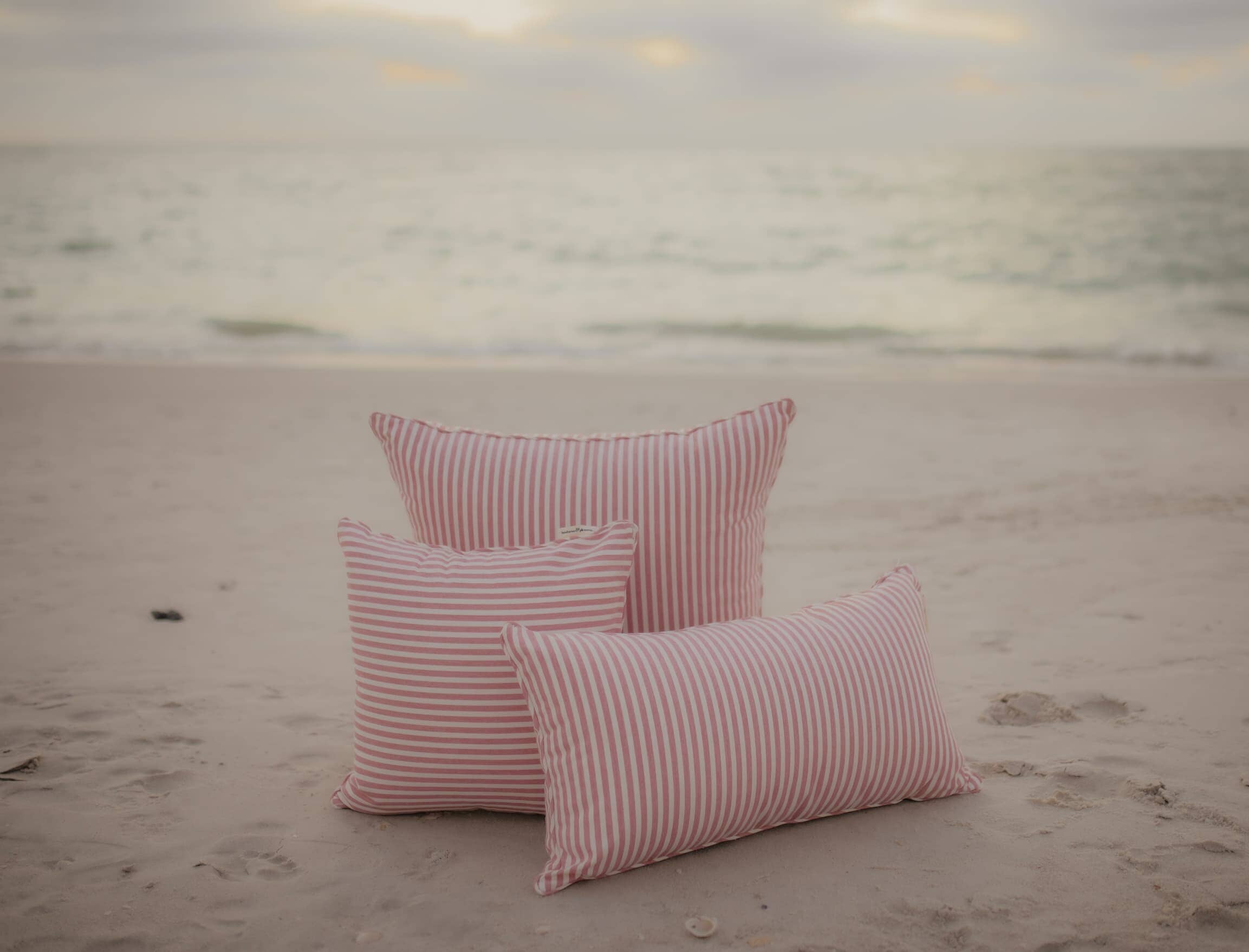 pink throw pillows on the beach