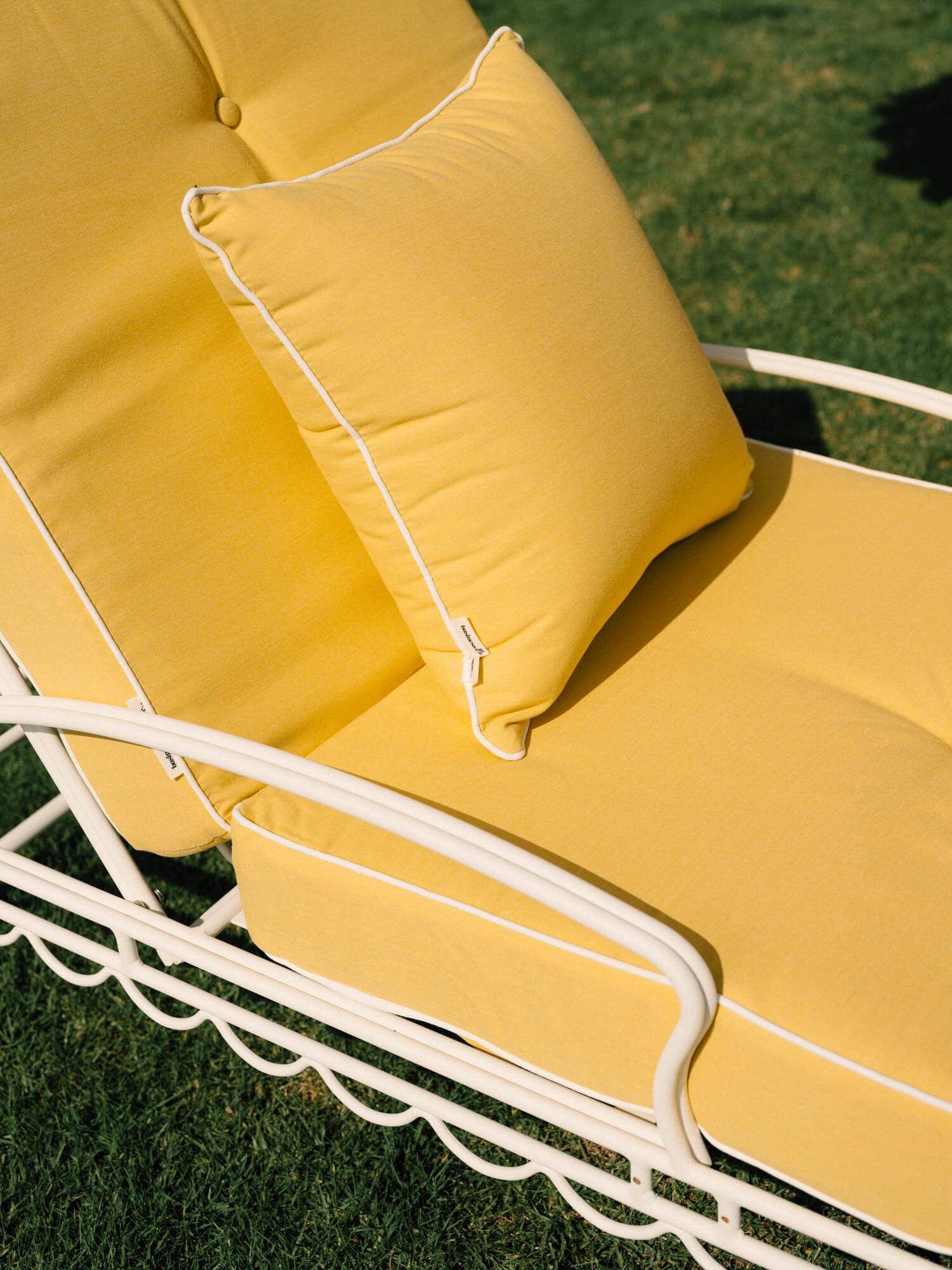 Riviera mimosa small throw pillow on an outdoor sun lounger