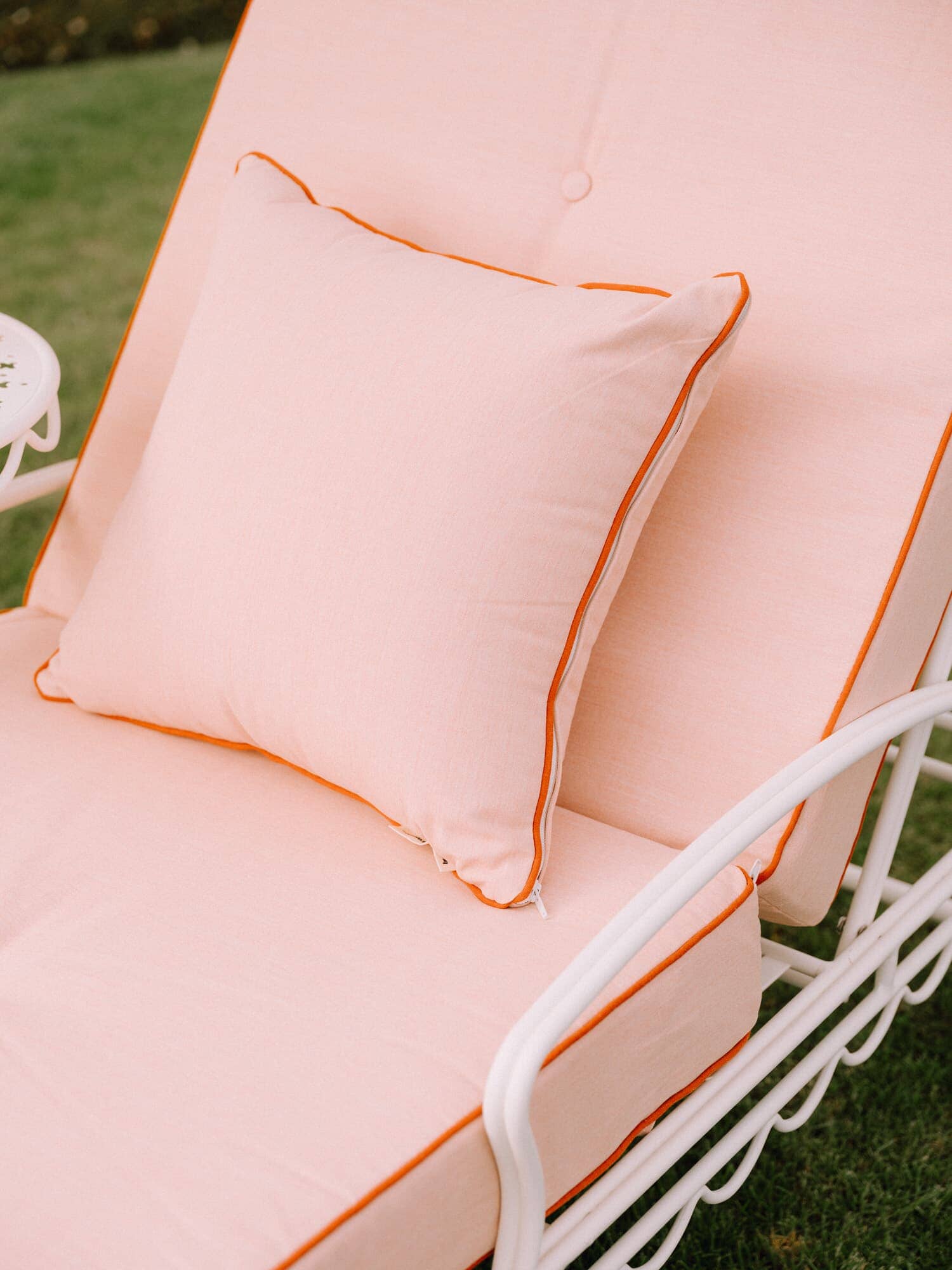Riviera pink small throw pillow on an outdoor lounger