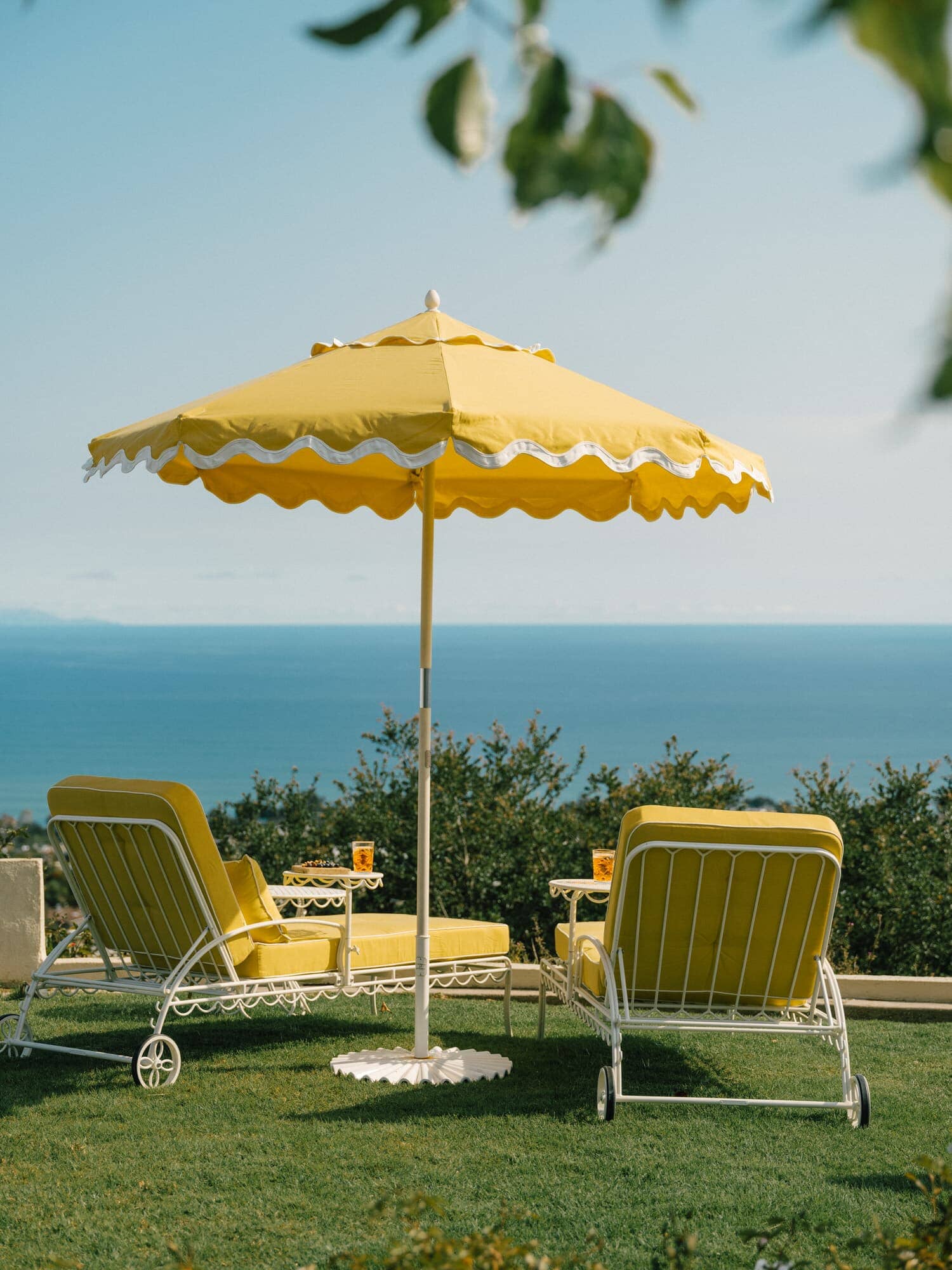 Riviera mimosa sun loungers and umbrella on a grass area
