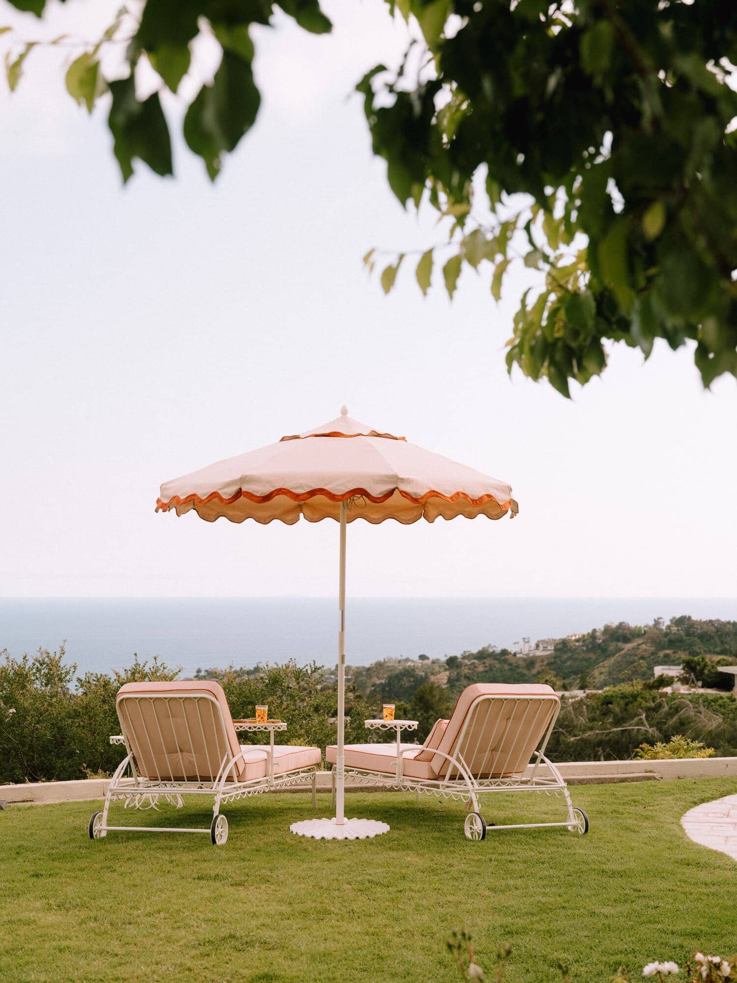 Riviera pink sun loungers with umbrella on the grass