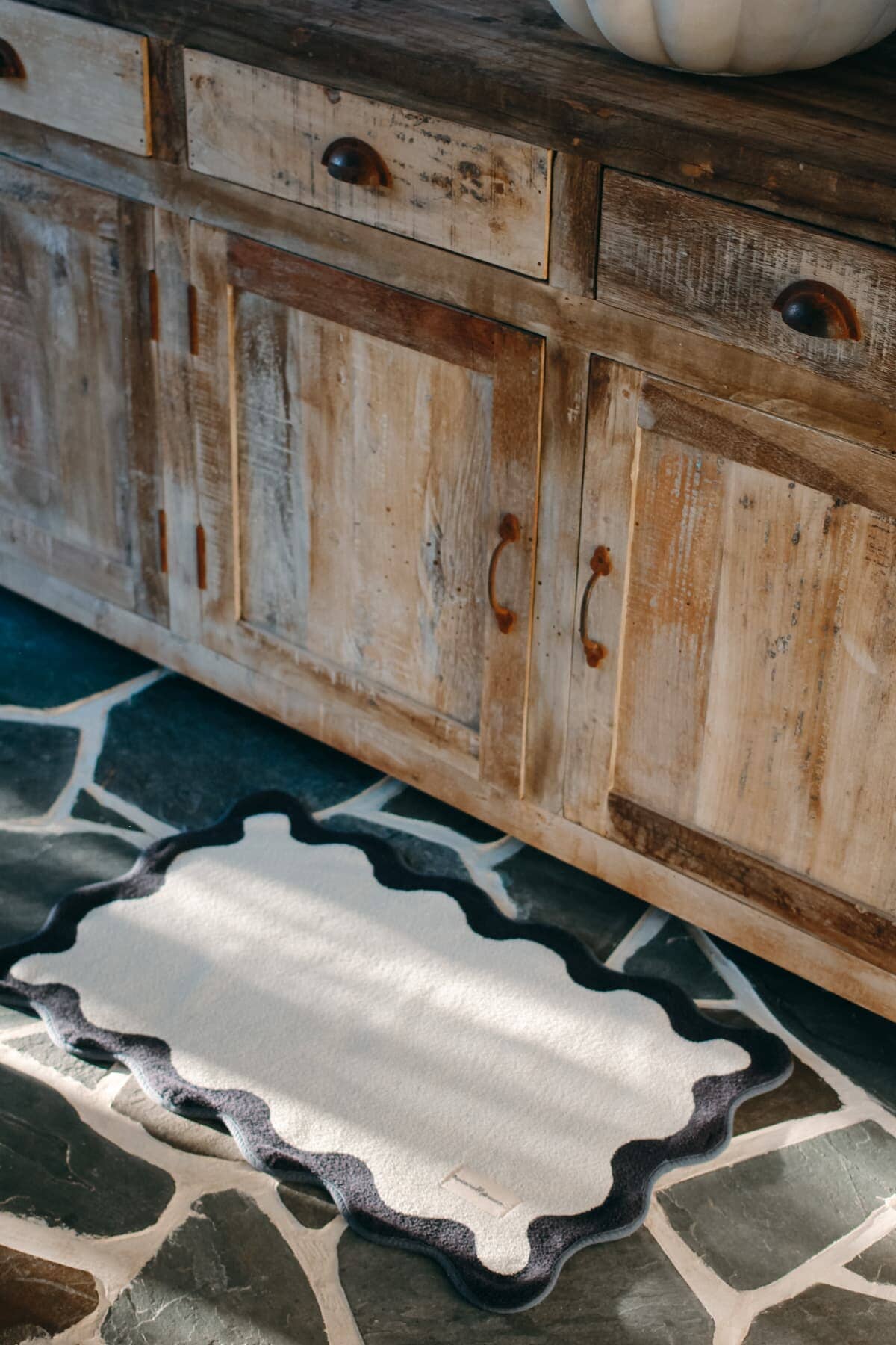 White bath mat on a stone floor