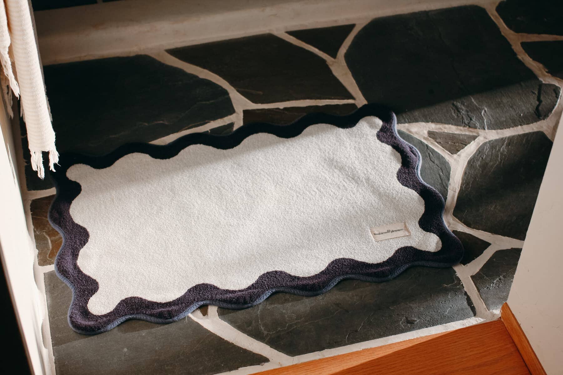 White bath mat on a stone floor