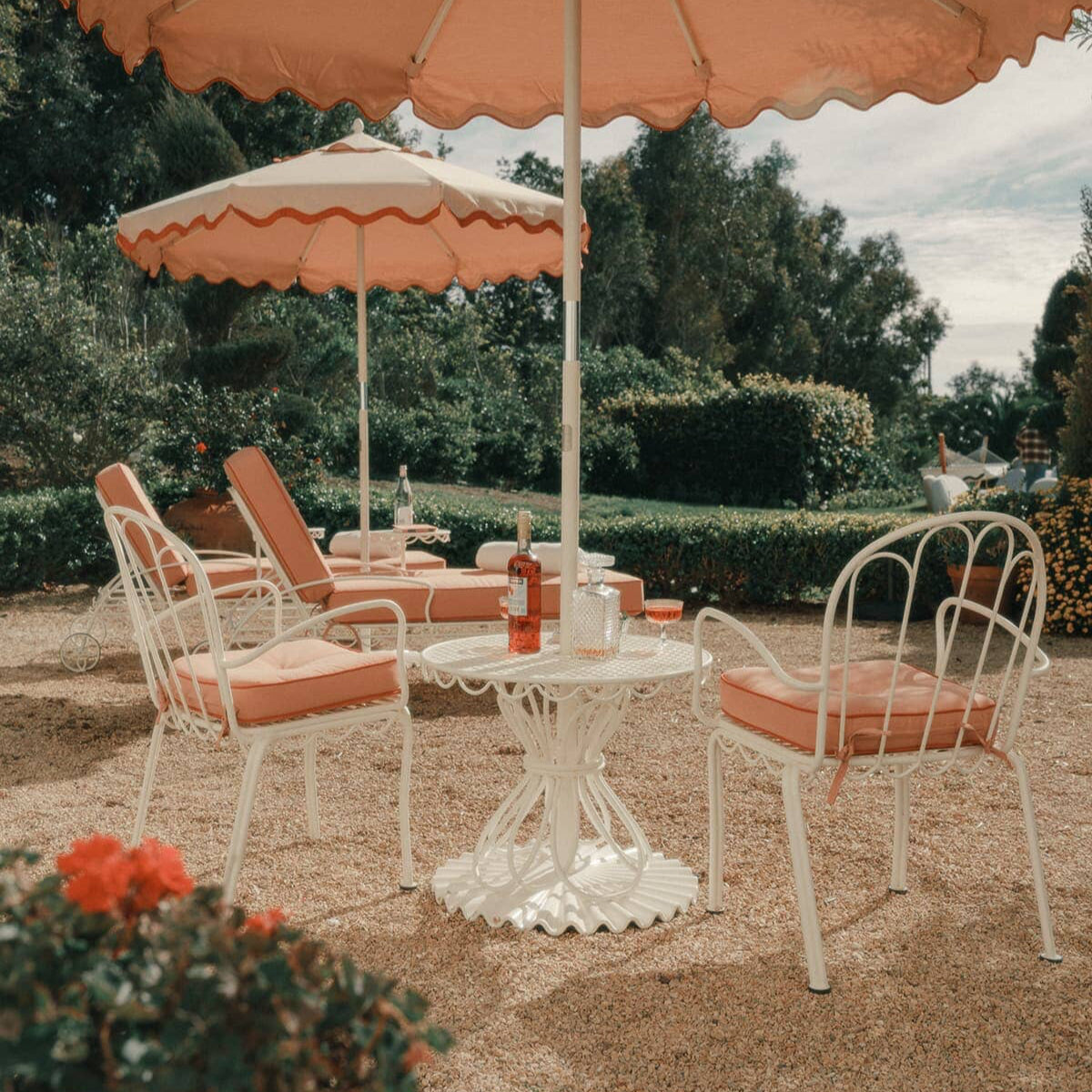 Side table with chairs and pink umbrellas in an outdoor courtyard