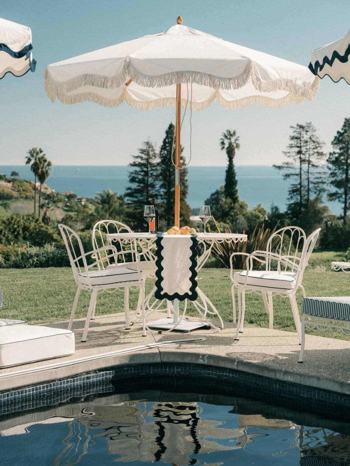 al fresco dining table, chairs next to a pool