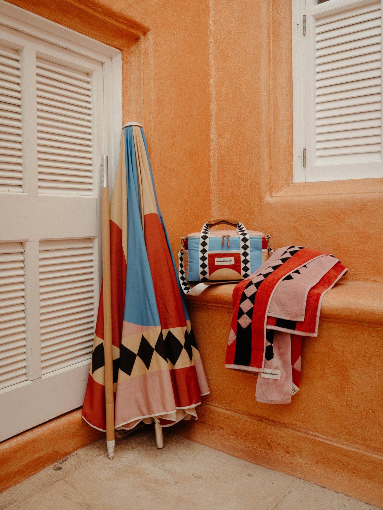 diamond pink amalfi umbrella leaning against a wall