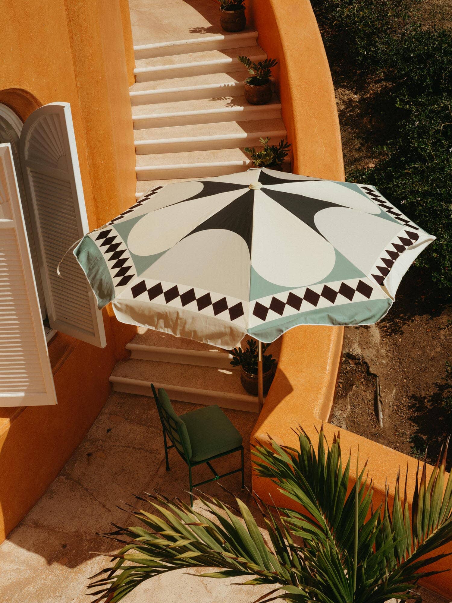 Diamond Green Amalfi Umbrella next to a staircase