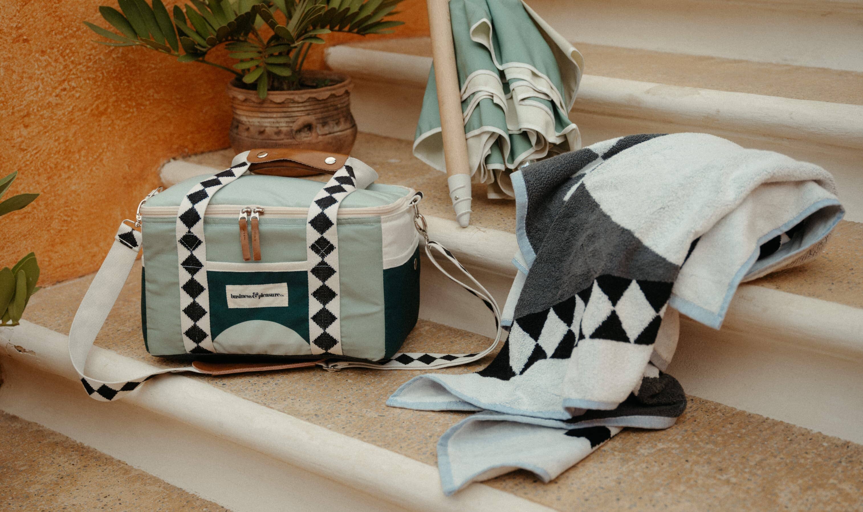 green diamond cooler, towel and umbrella on stone steps