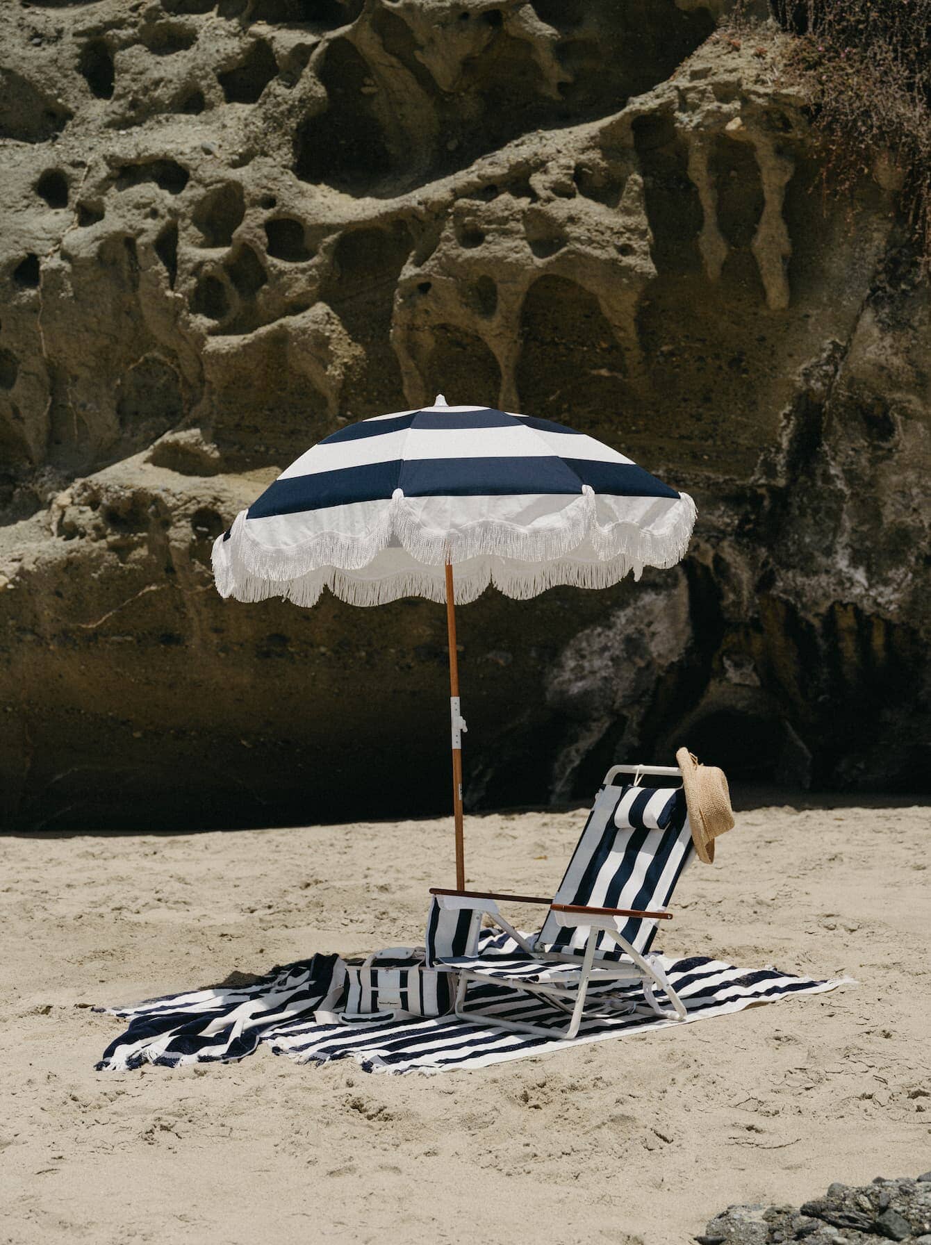navy holiday beach umbrella on the beach with beach chair and towel