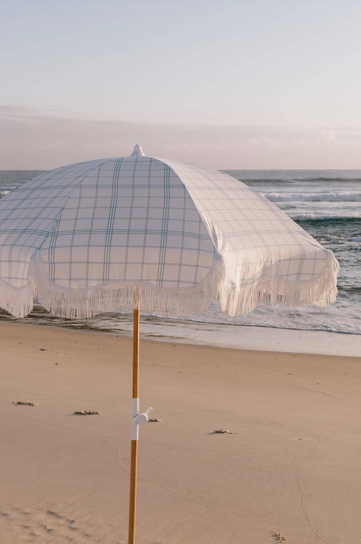 blue plaid holiday umbrella on the beach