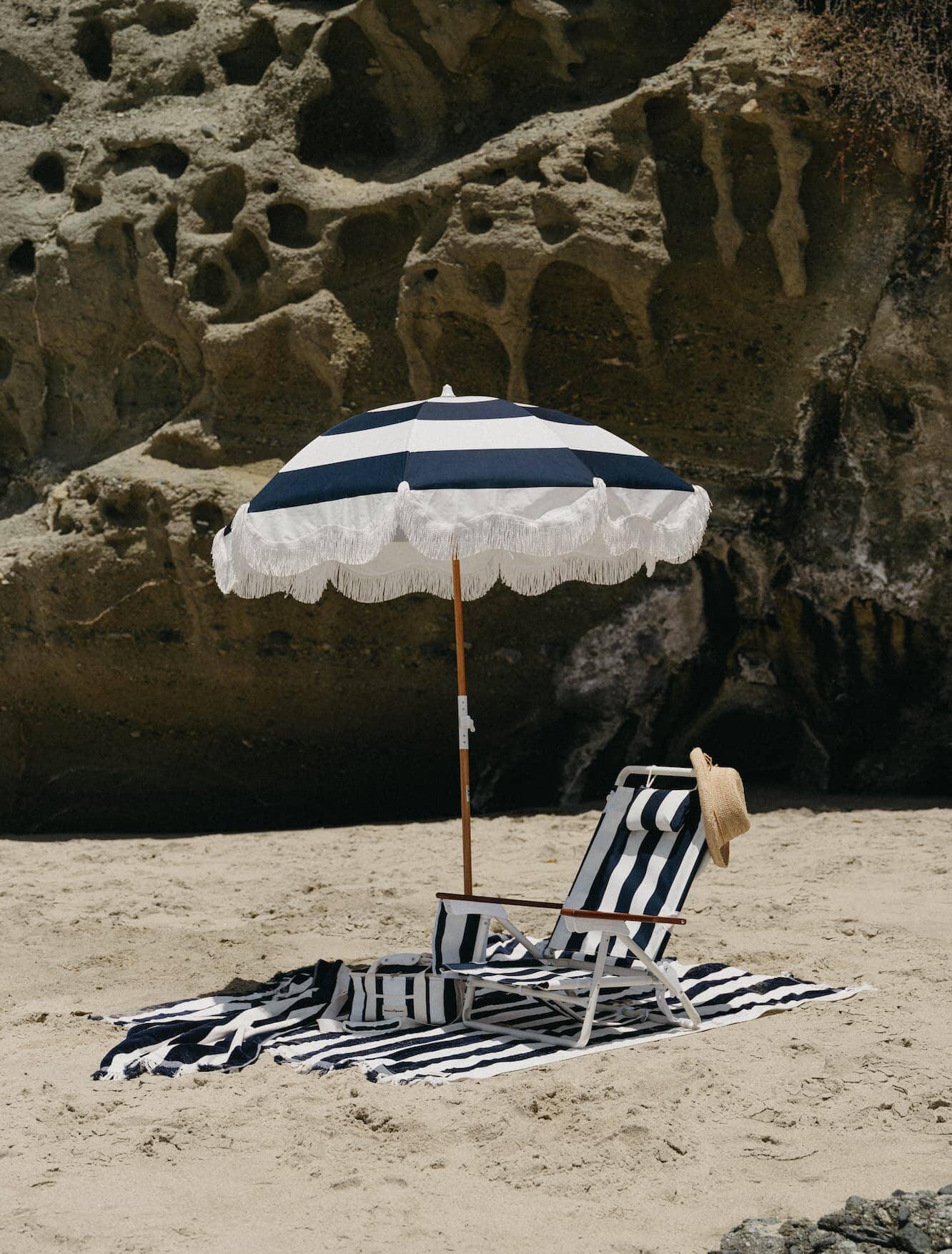 navy holiday tommy, umbrella and blanket on a beach