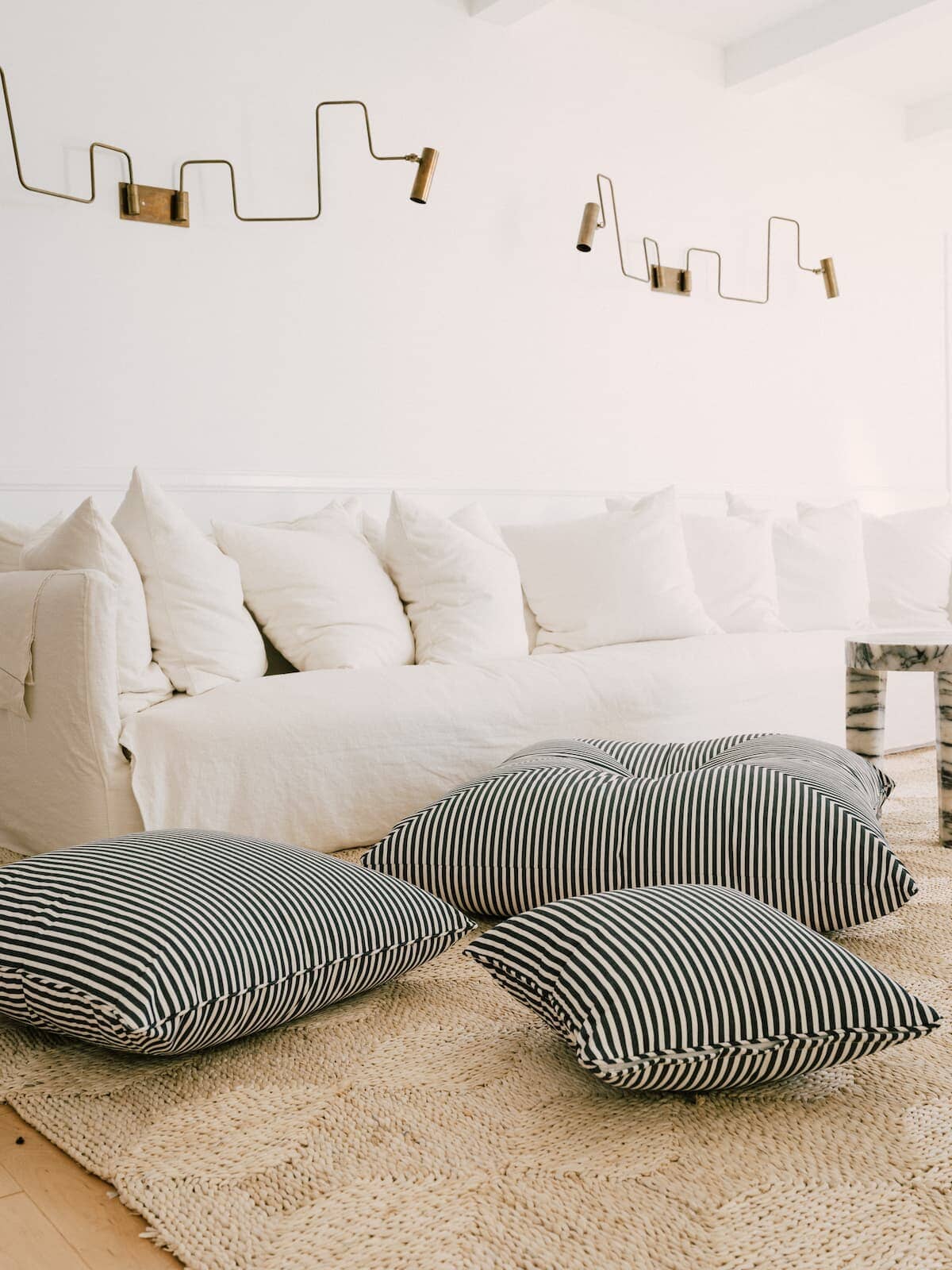 3 outdoor cushions scattered on a living room floor