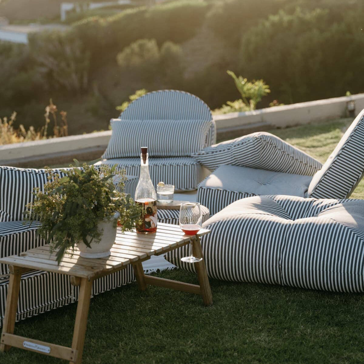 outdoor picnic setting featuring reclining lounger and floor pillow