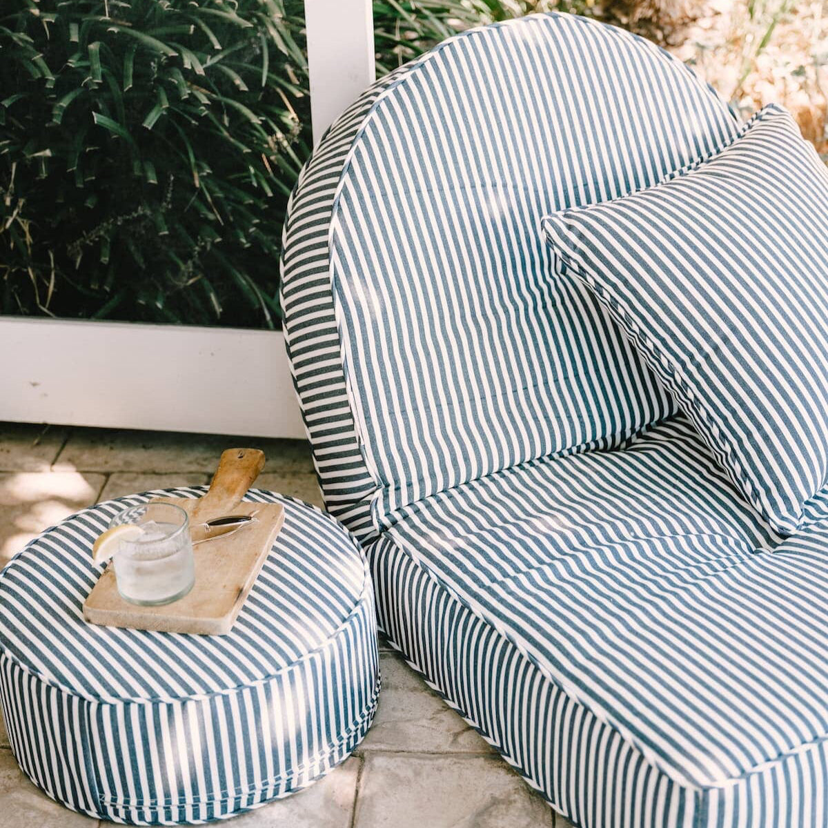 Lifestyle image of the reclining lounger on a patio with a drink