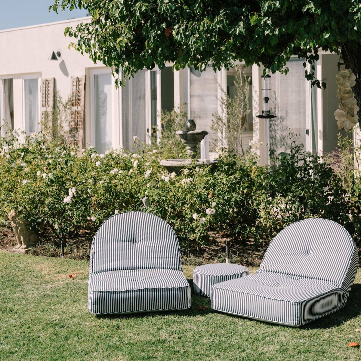 Lifestyle image of 2 reclining loungers in a garden setting